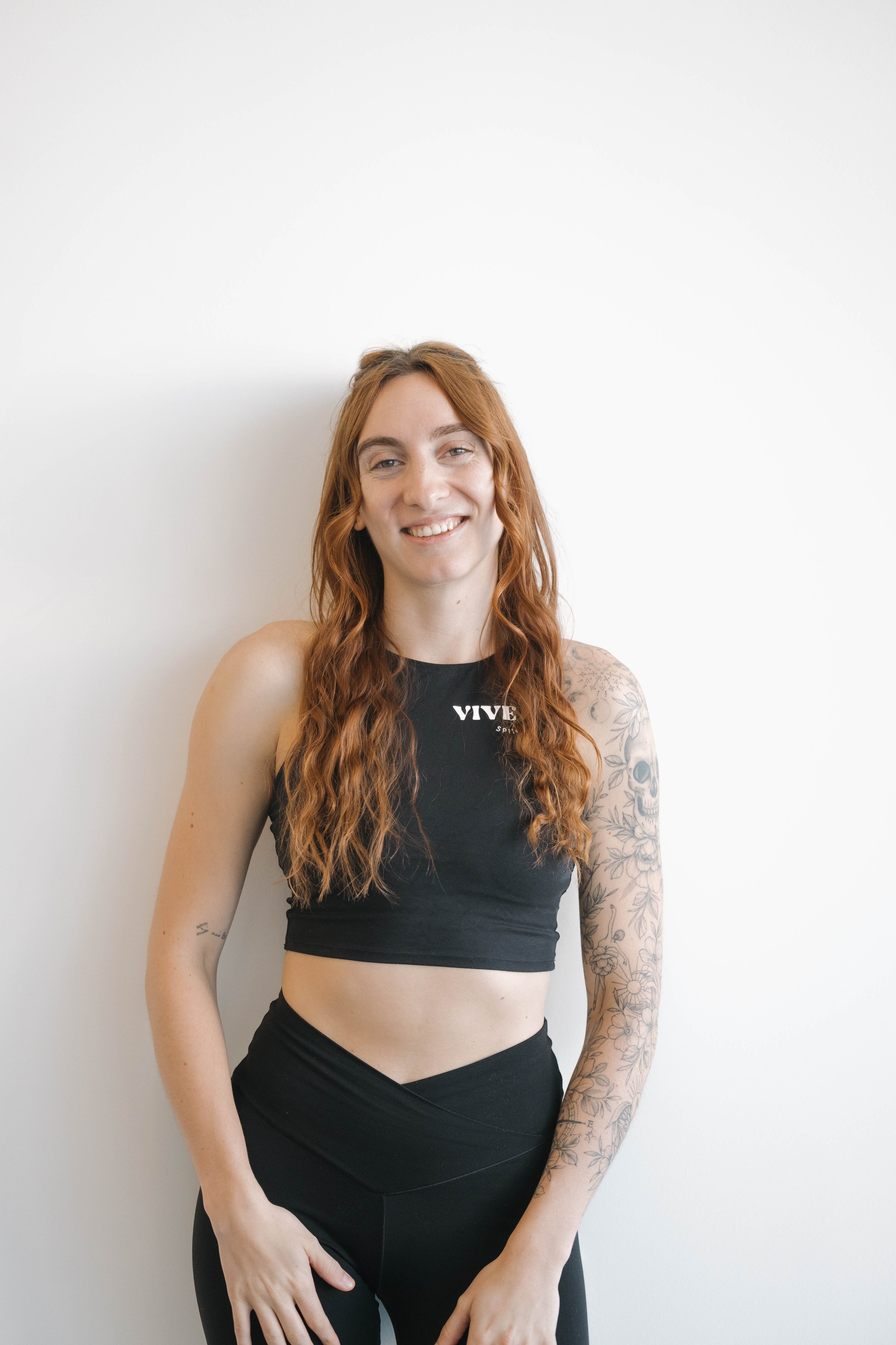 Women wearing black sports bra with "VIVE" in white letters