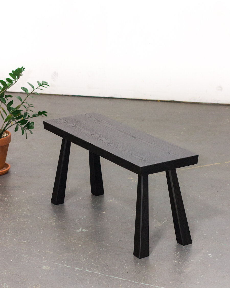 a black wooden bench with 4 legs