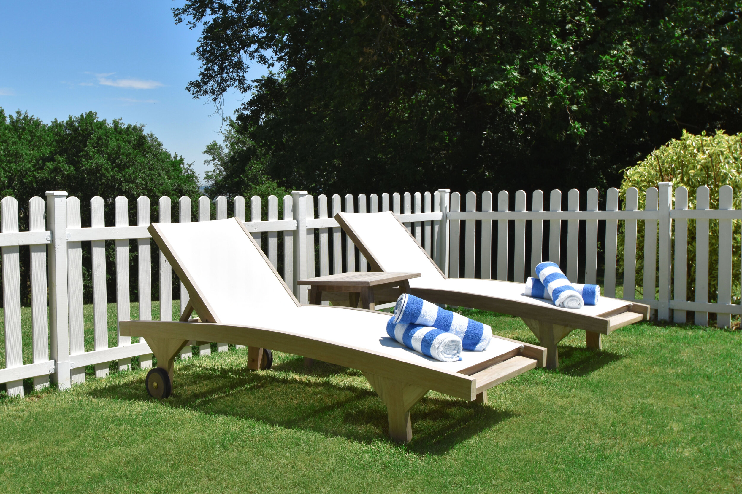 sunloungers on grass next to pool.jpg