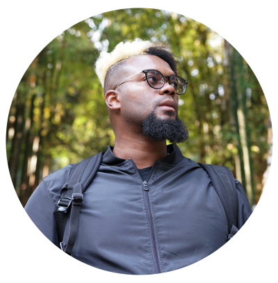 A headshot of New Orleans filmmaker Travis Henry with trees in the background.