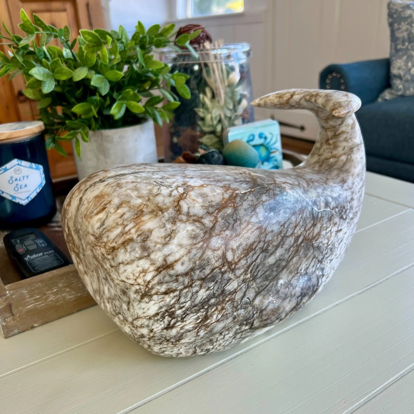 Completed. Meet Bartholomew. A hand-carved whale sculpture in alabaster, shaped with smooth, quiet curves that give the piece a calm but commanding presence. The stone&rsquo;s intricate brown, gray, and cream veining moves across the surface like wea