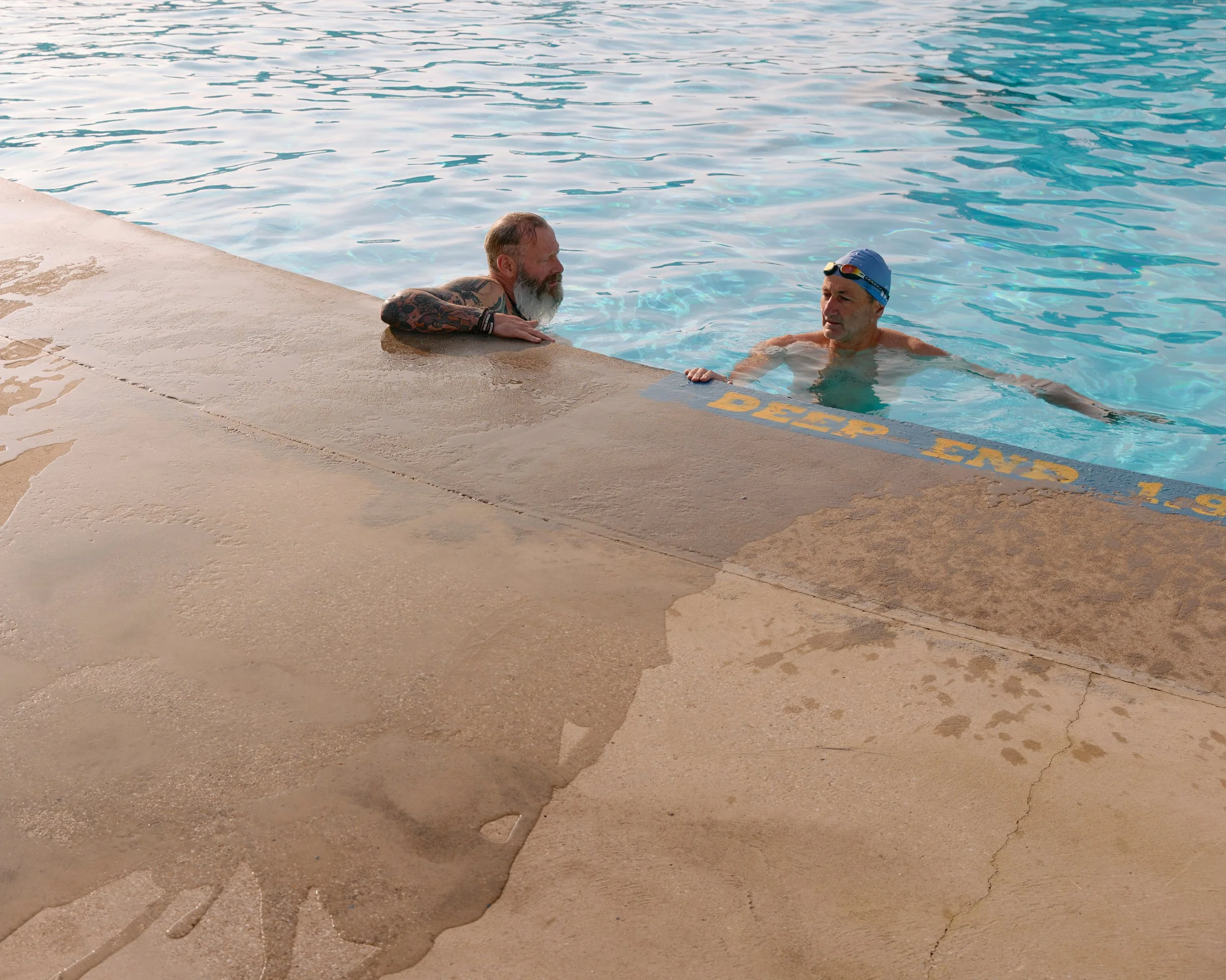 Two cold water swimmers in an outdoor pool in Yorkshire, England