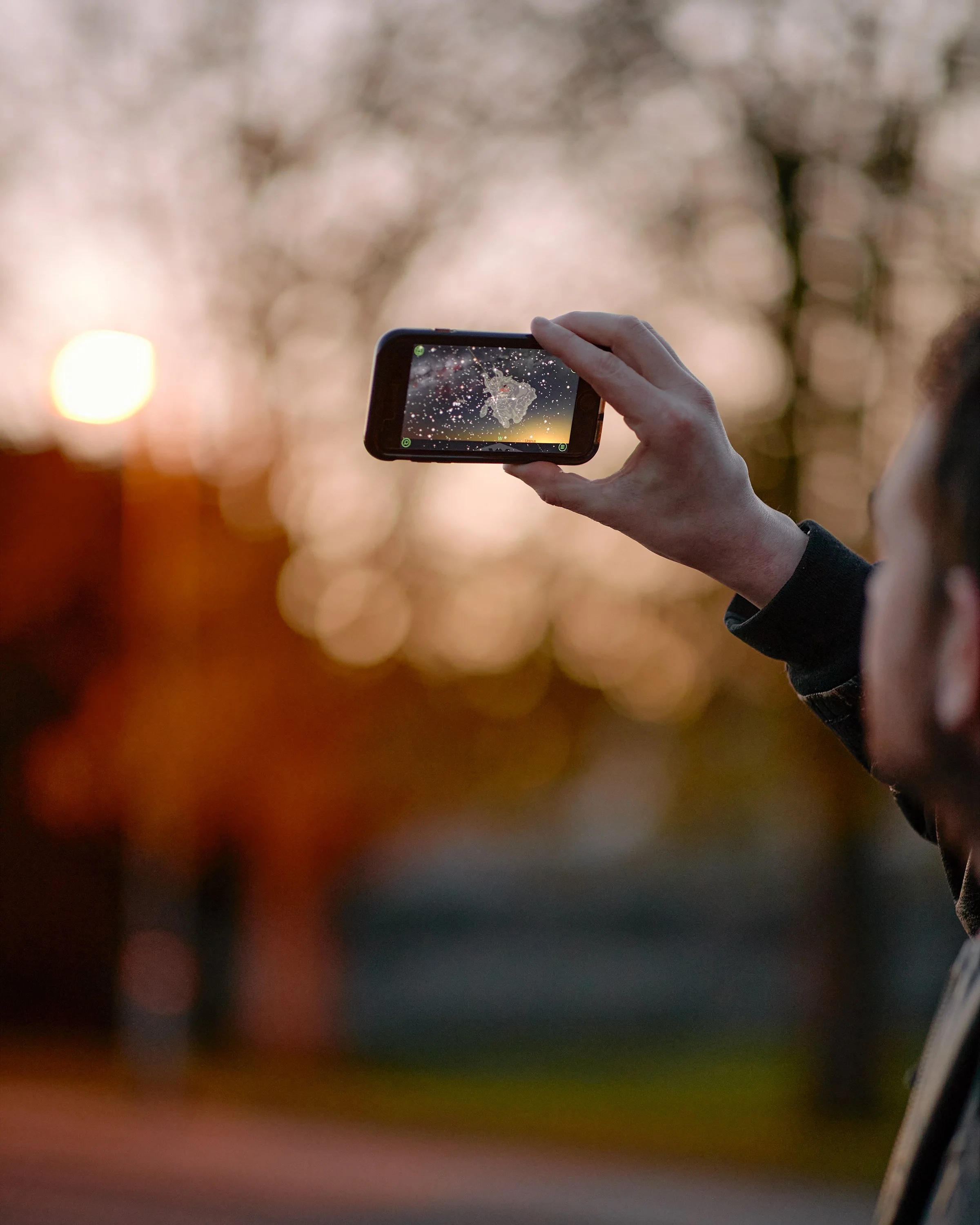 A man using a phone to track stars in the evening sky in Yorkshire, England.