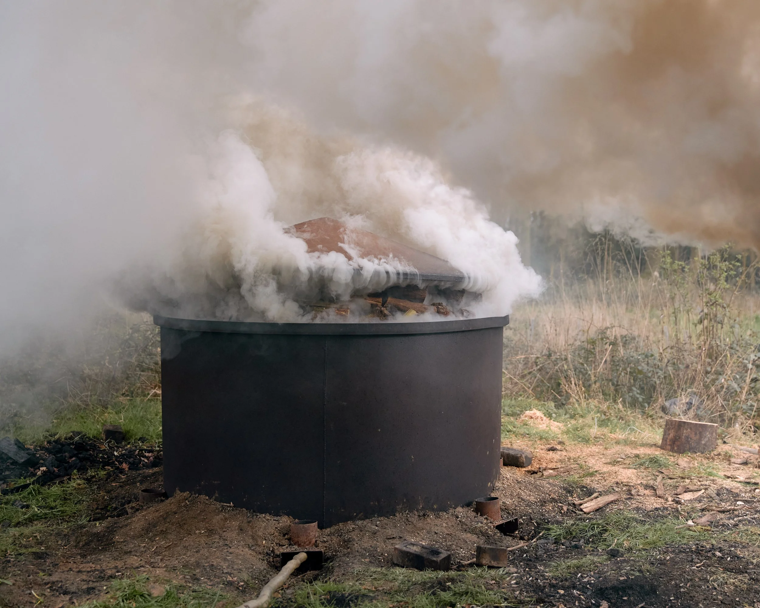 Smoke rising from a charcoal kiln in Yorkshire, England.
