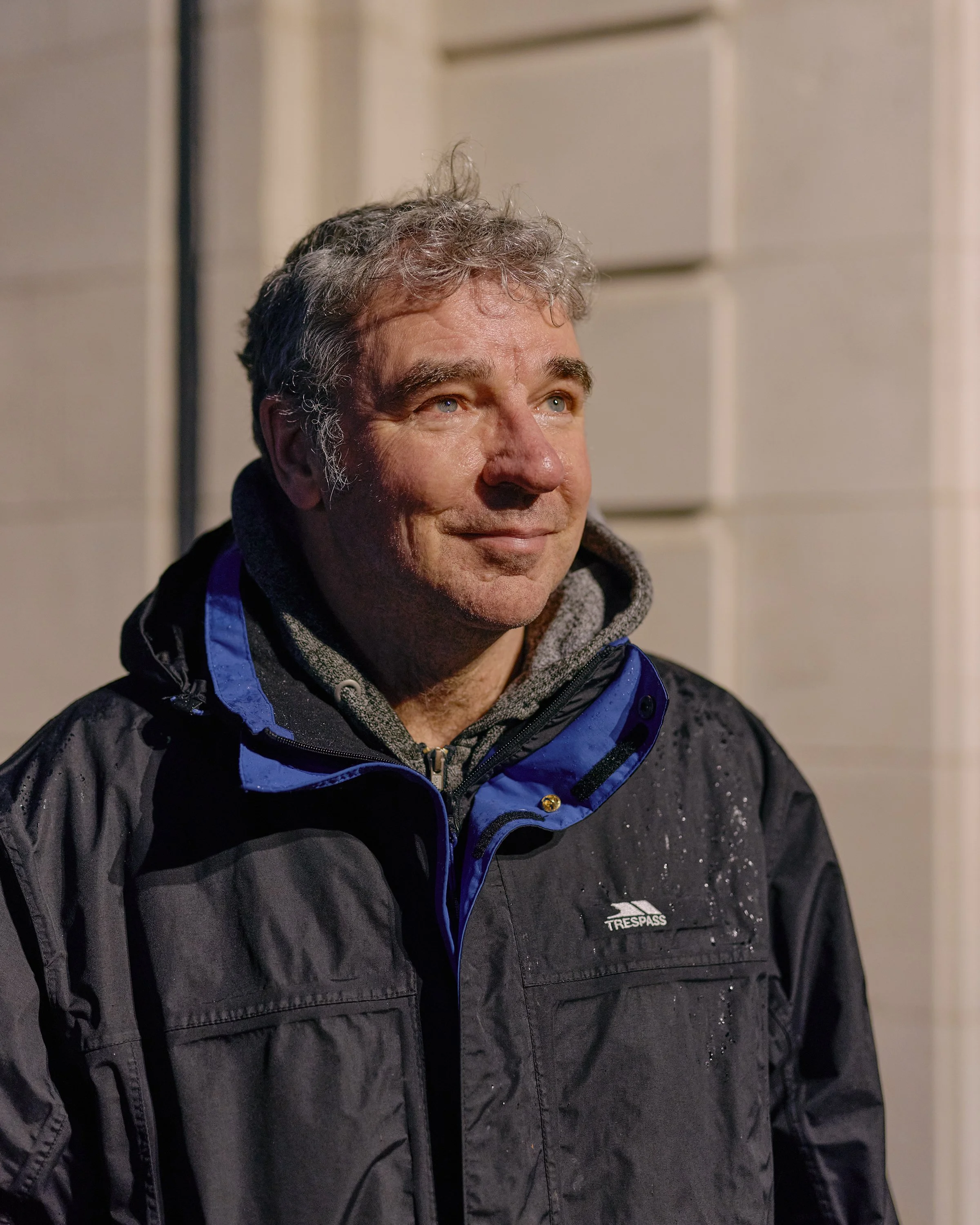 A man standing beneath a street light on a rainy evening in Middlesbrough.