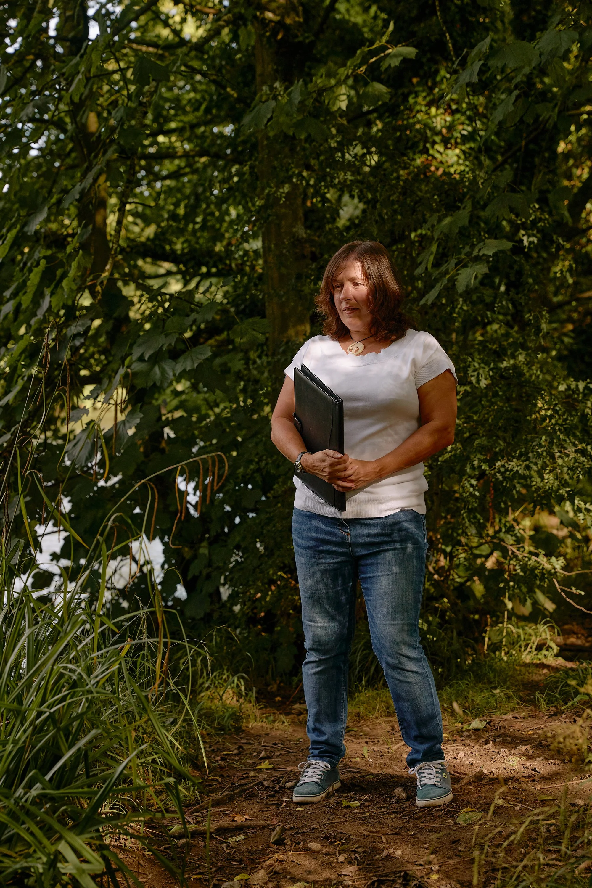 A citizen scientist standing in dappled woodland light in Wharfedale, England.