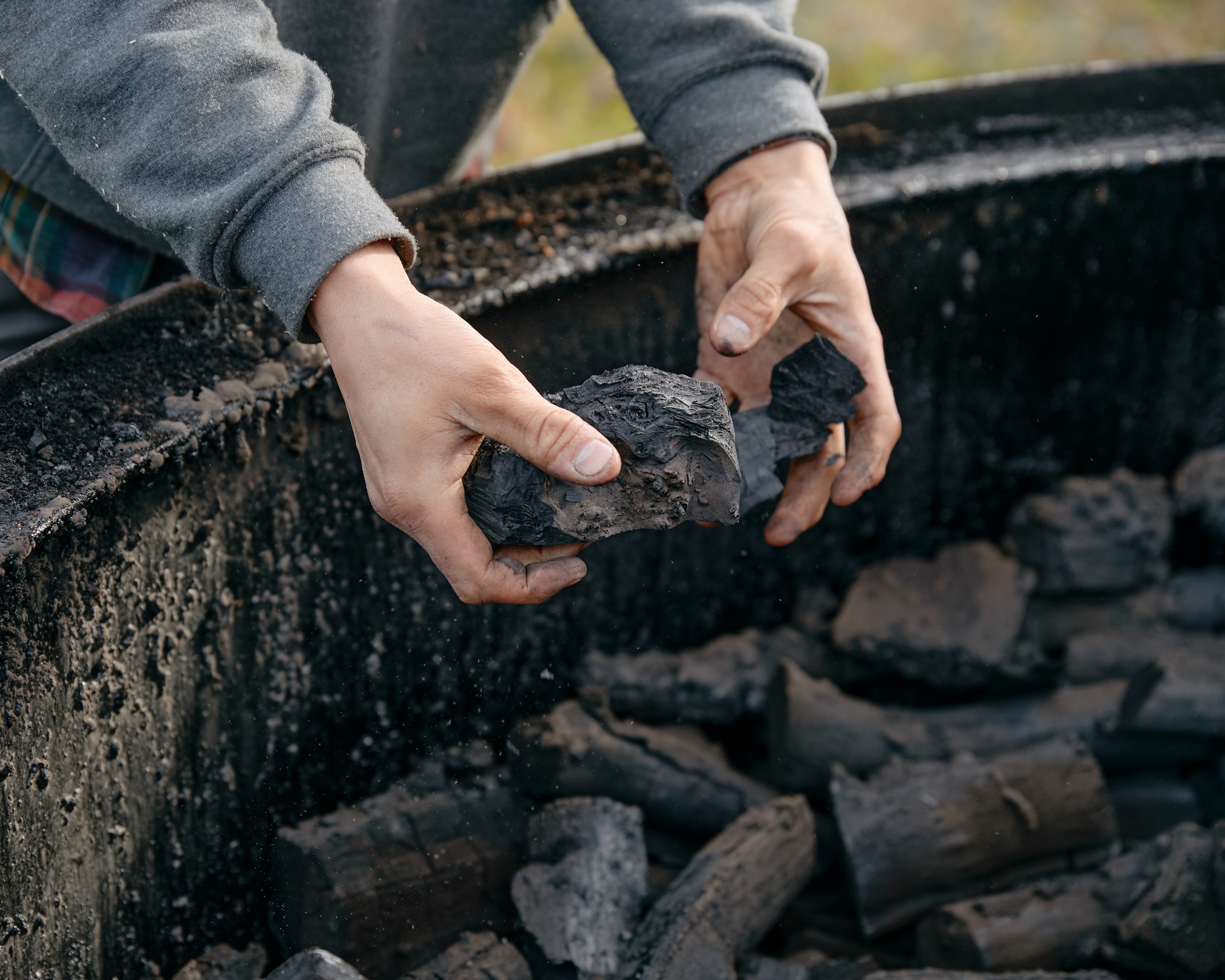 A person holding pieces of charcoal in Yorkshire, England.