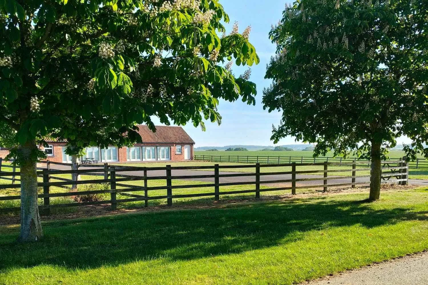 Exterior view of the Academy of Sound Therapy training building nestled among mature trees as seen from the peaceful driveway entrance in Ingoldsby, near Grantham, Lincolnshire.