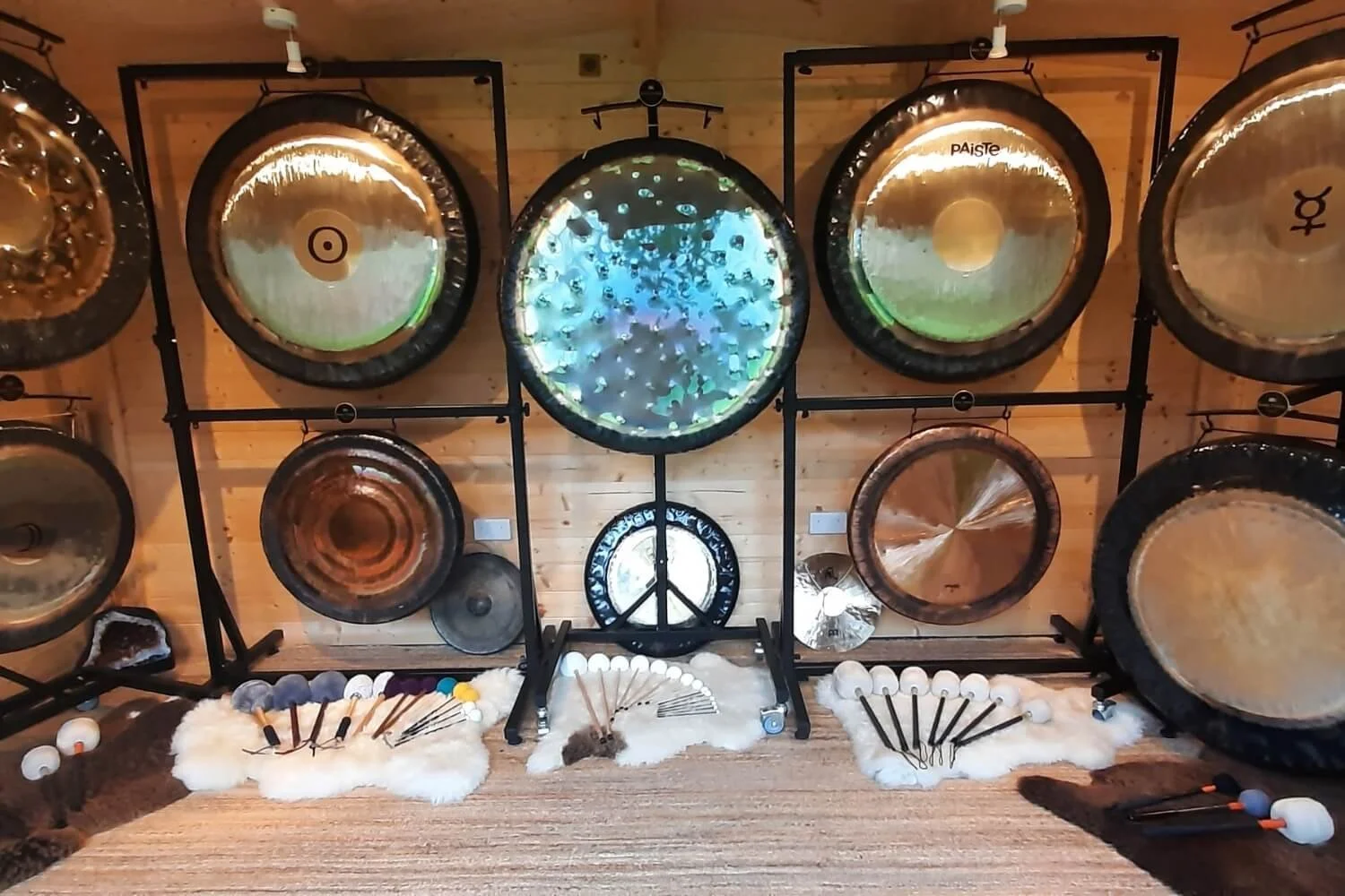 A comprehensive line of professional master gongs arranged inside the dedicated timber cabin training sanctuary at the Academy of Sound Therapy in Stretton, Rutland.
