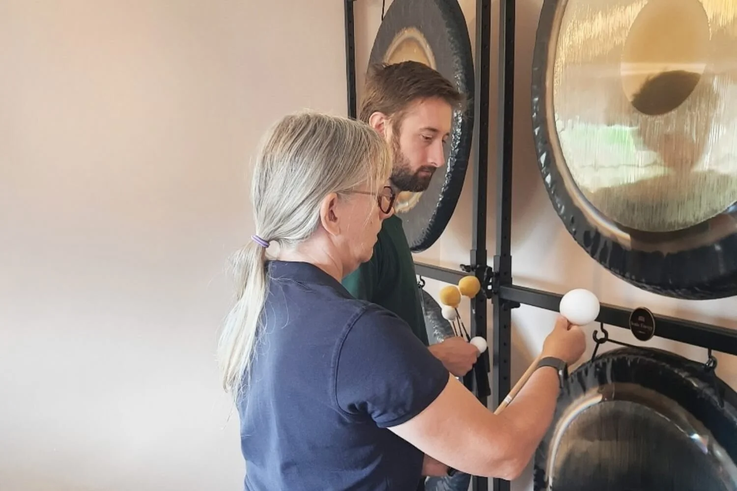 An advanced sound therapy training session showing tutor Helen Campbell giving precise instruction to a practitioner student on how to use friction gong flumies to invite deep harmonics at her Lincolnshire academy near Grantham.