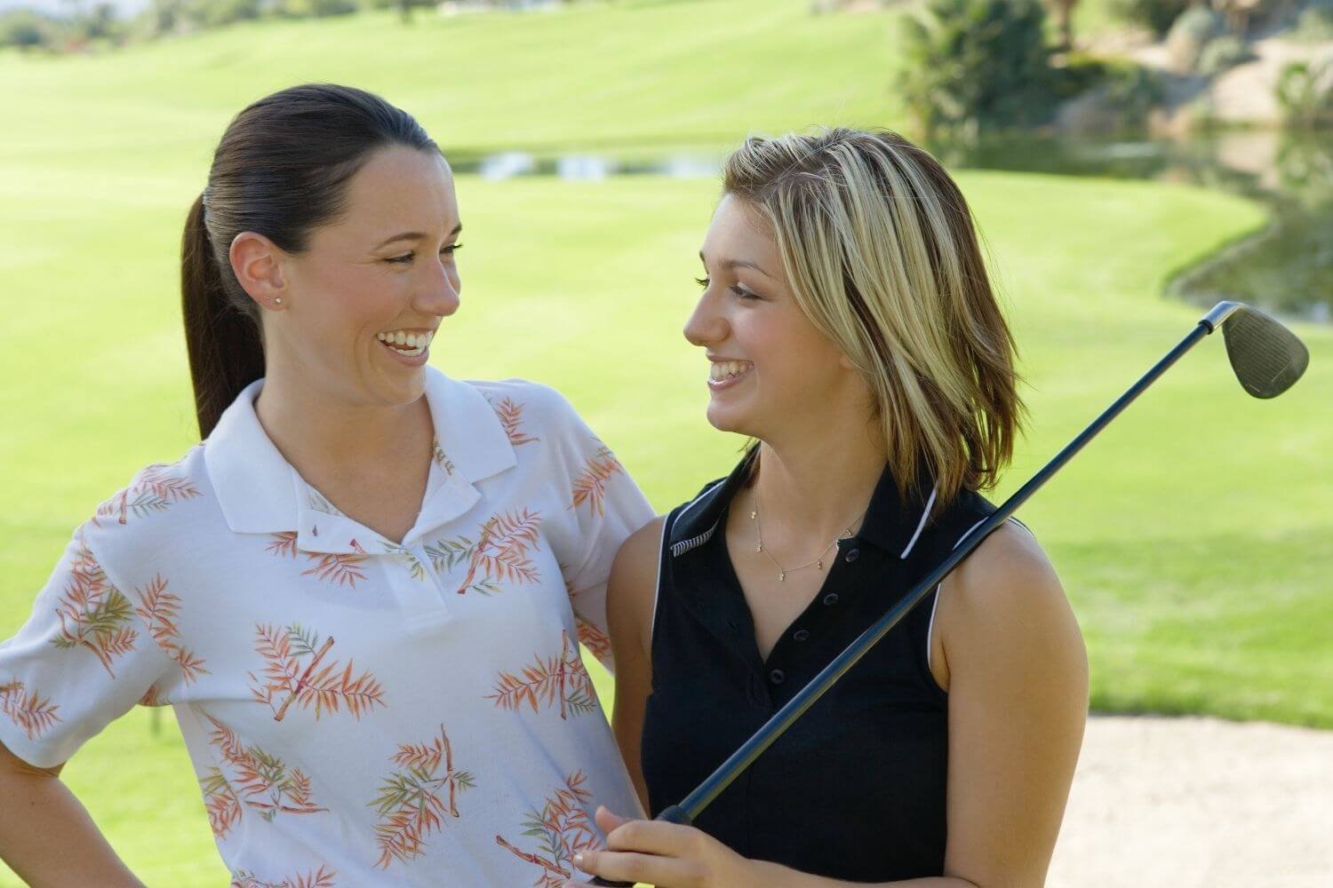 Two female golfers laughing on the golf course