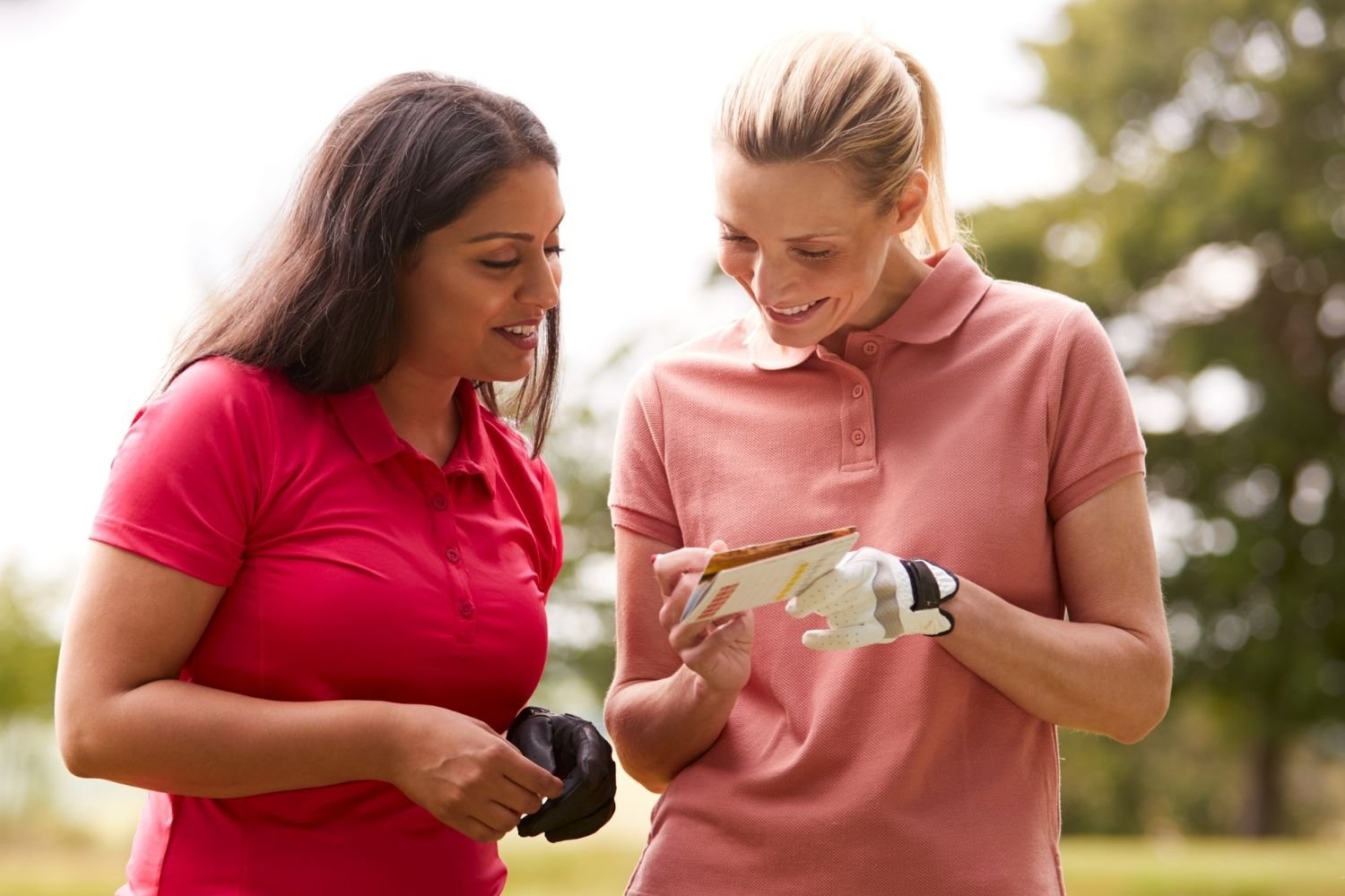 Two female golfers looking at a scorecard