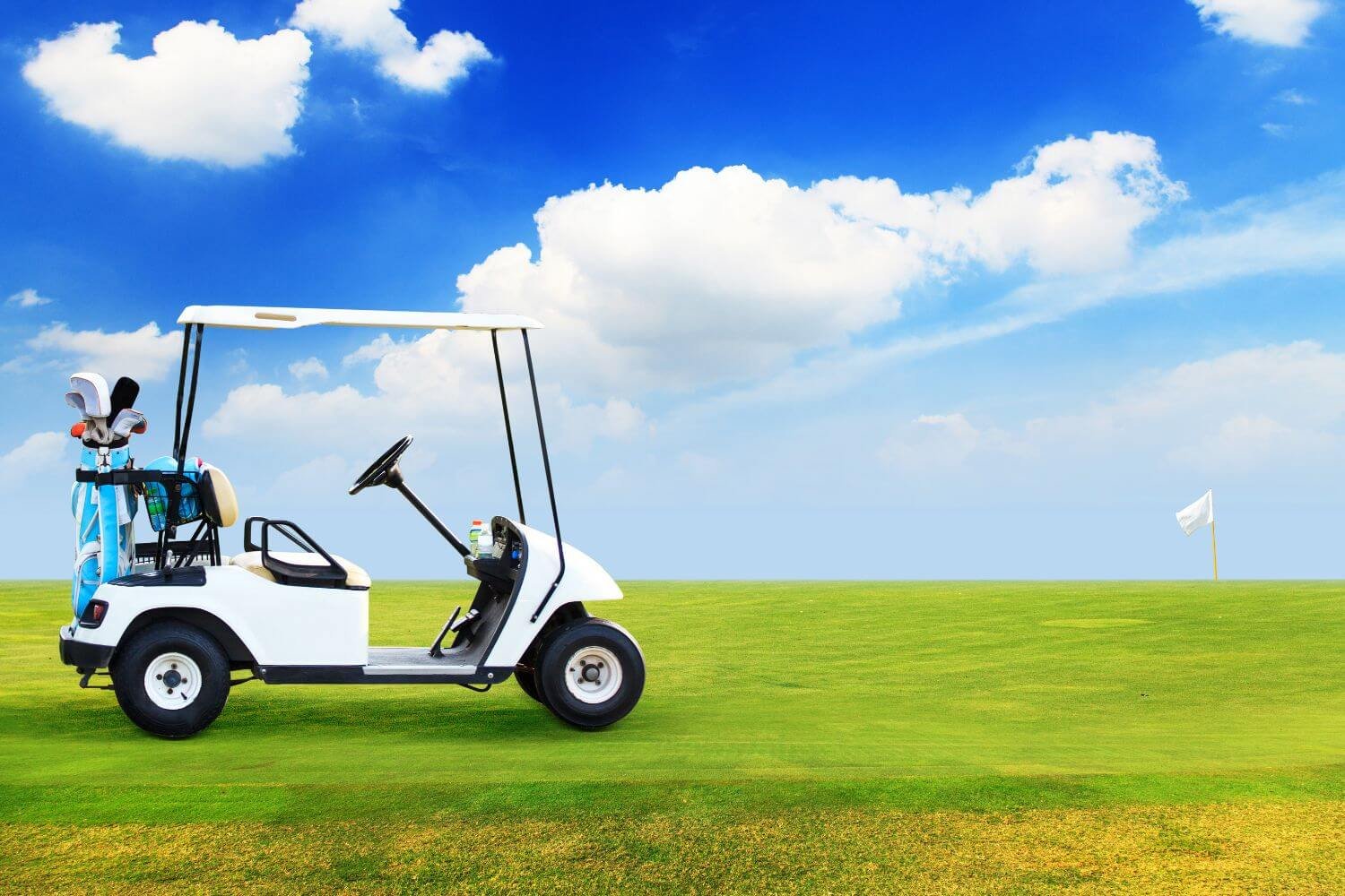 golf cart on golf course with blue sky and clounds