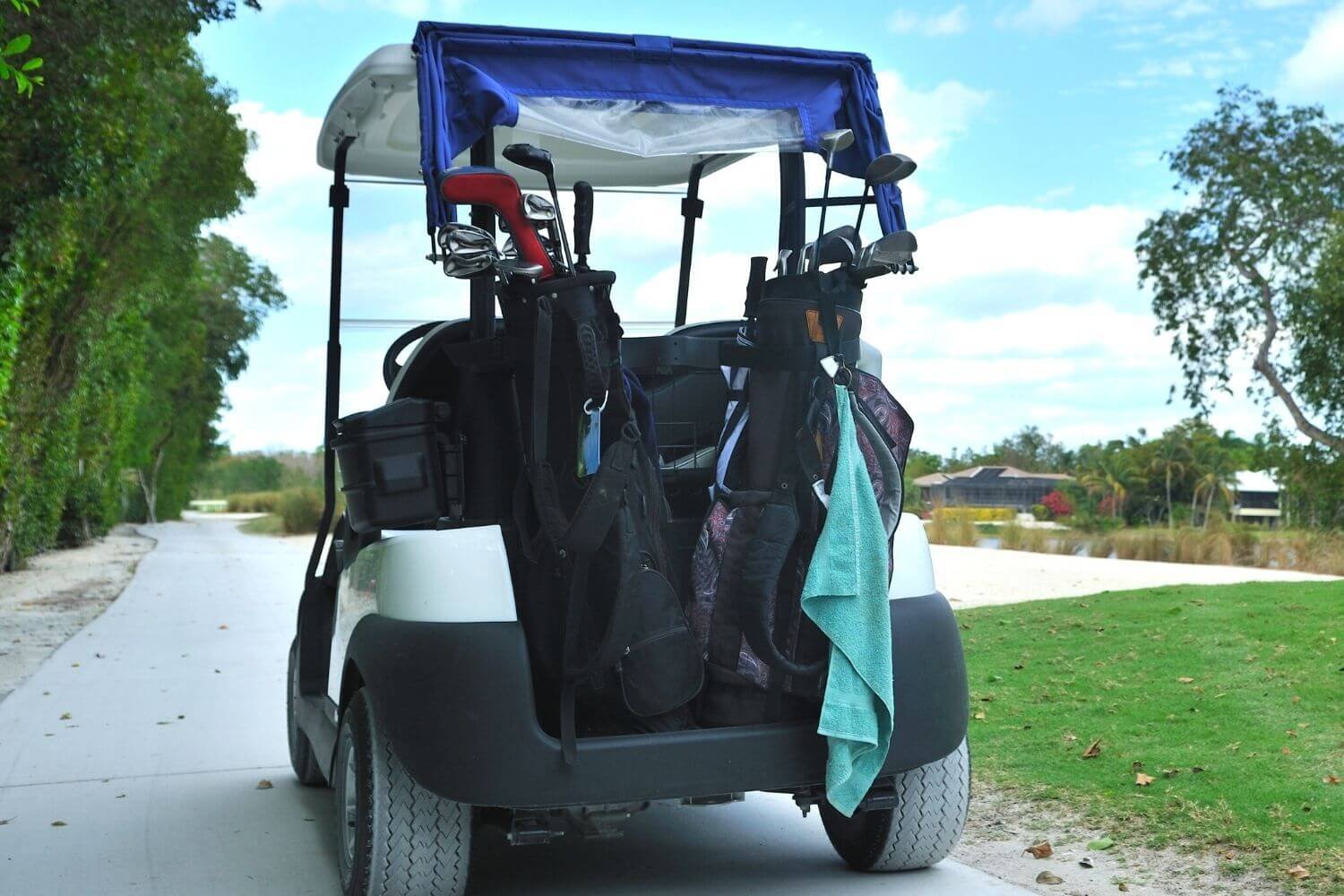 golf cart with golf bags and golf towels on the back