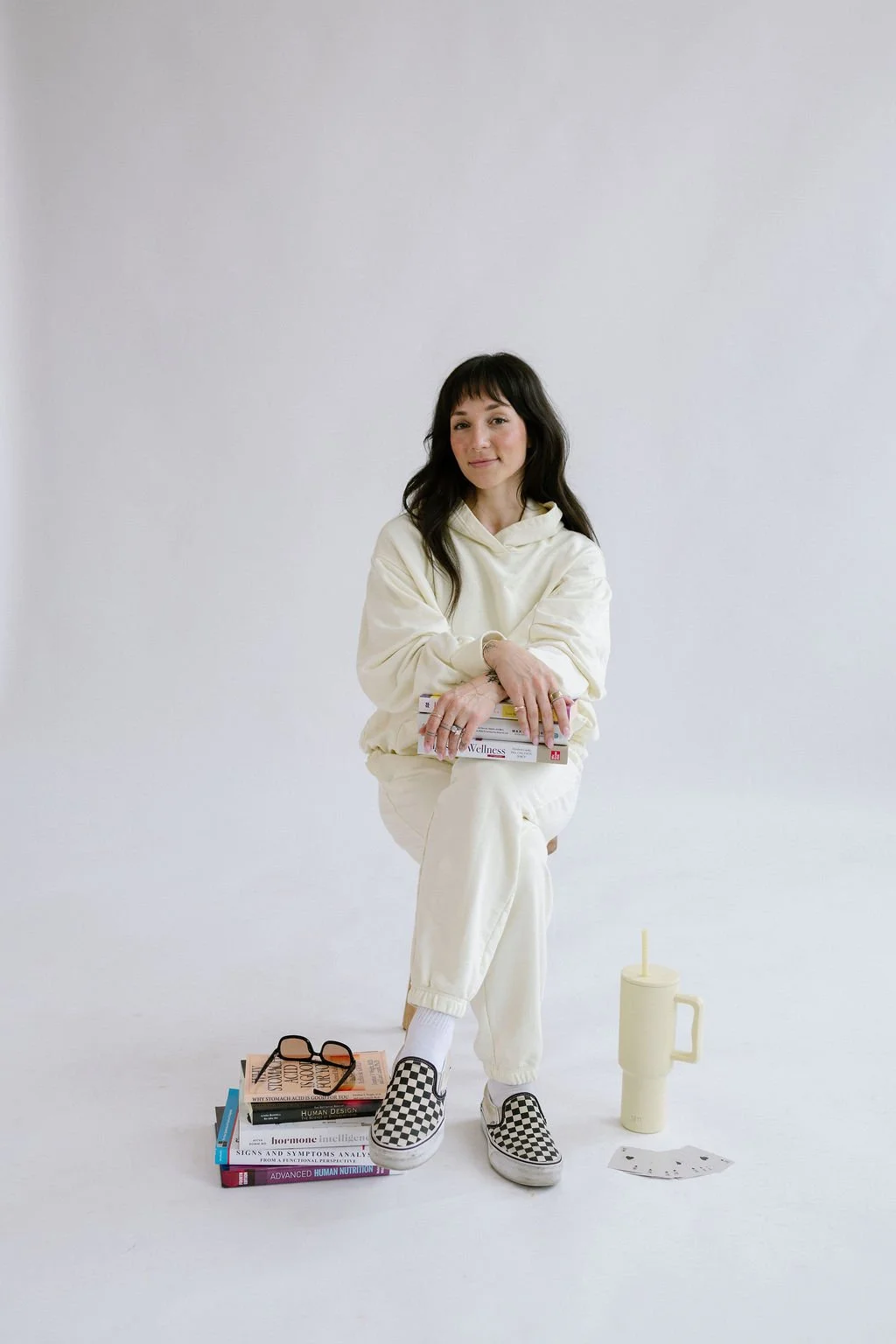 Elena Lee, GI Health Specialist, poses on a chair, ready to help coach women in nutrition.