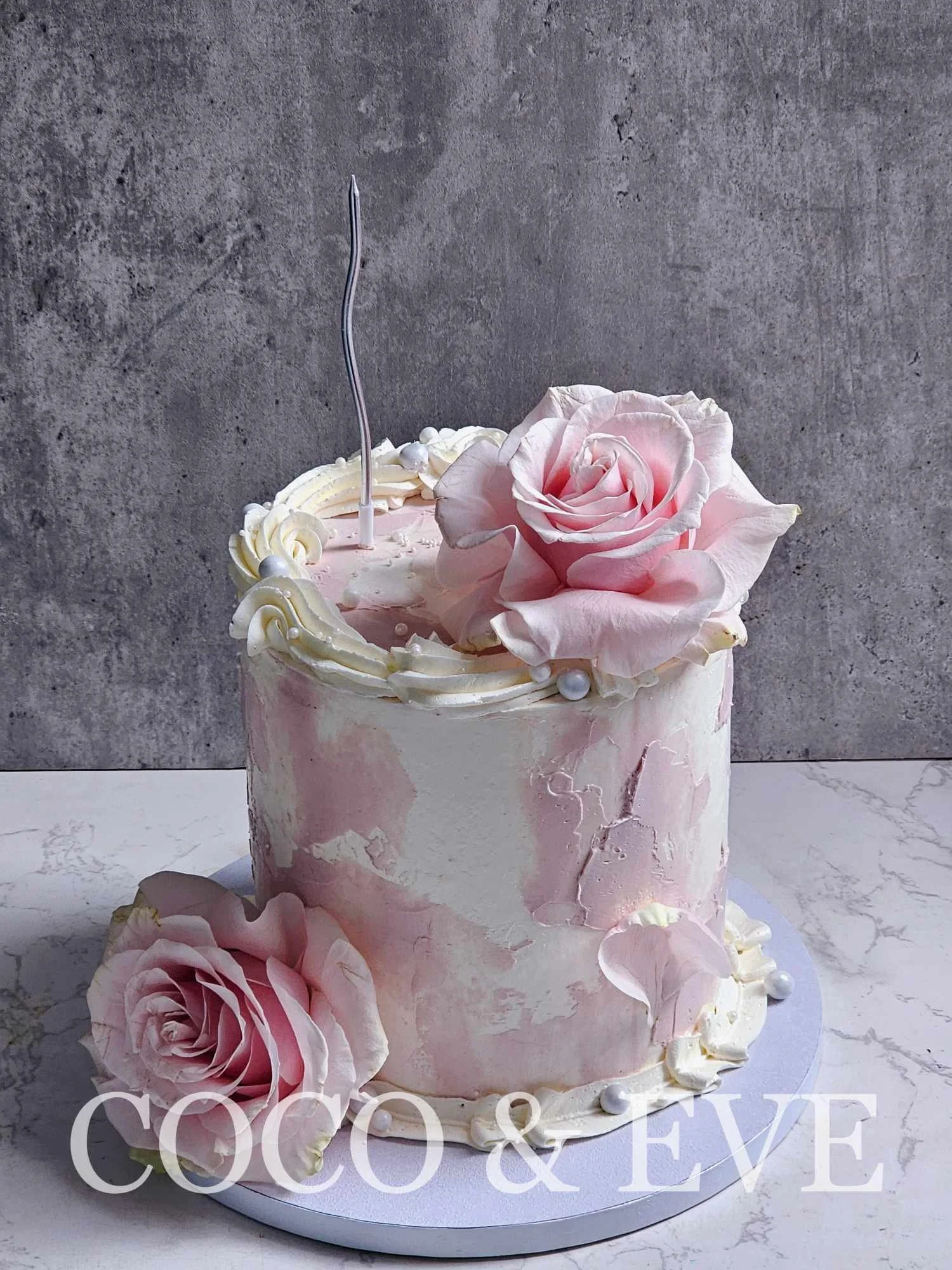 LADY ROSE:
Simple pink and white buttercream cake with pink roses.  (color of florals depends on the availability in the market)
6" $225