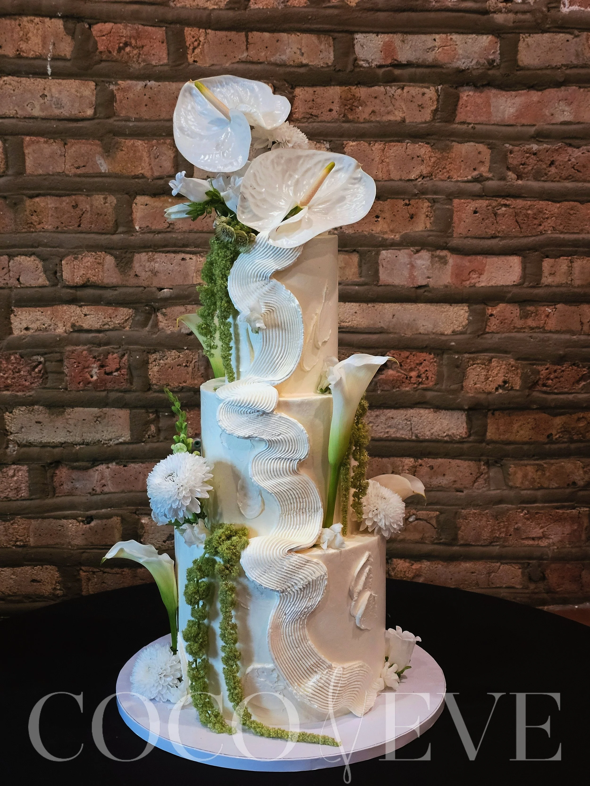 White wedding cake with greenery and florals.jpg