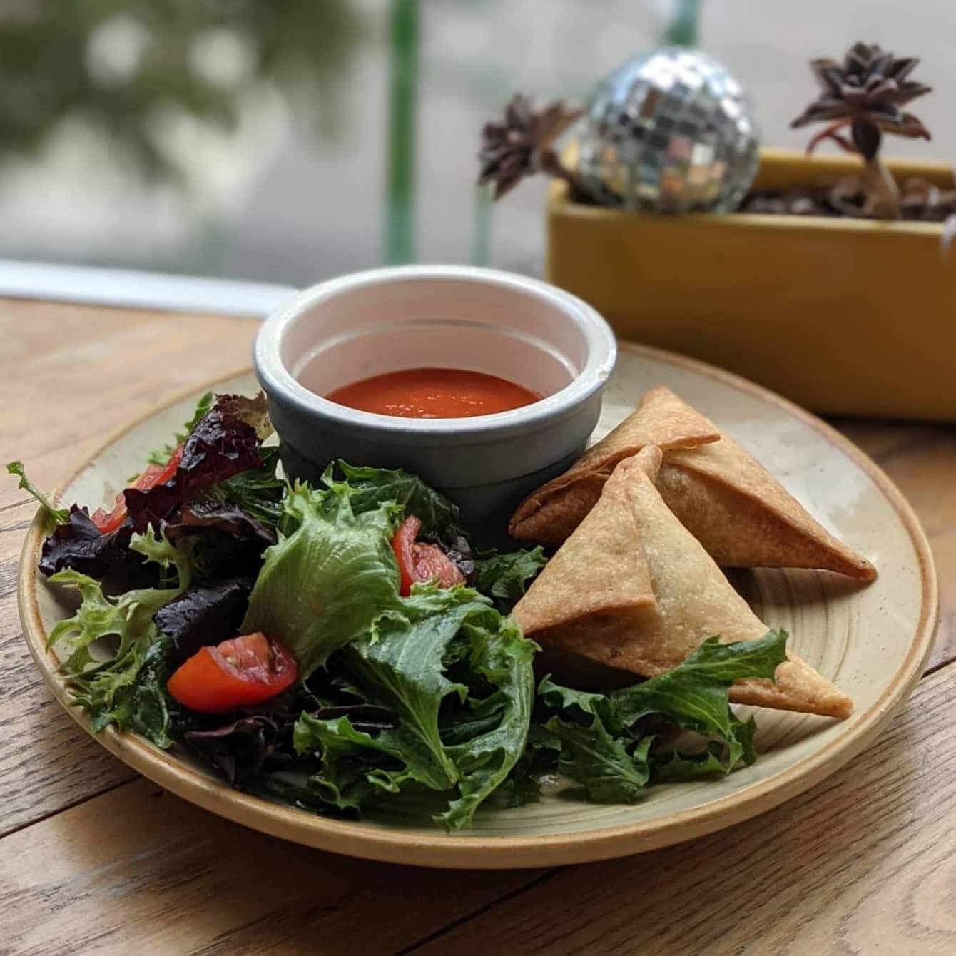 These chickpea and collard green samosas are one of our personal favorites 🤤 and don't get me started about how delicious that Sasa sauce is. They come paired with a side salad and are vegan!