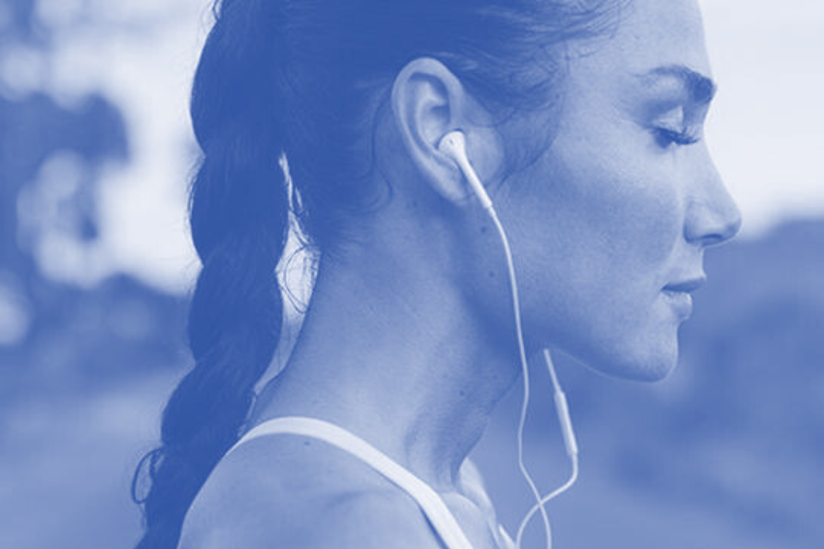 Side profile of a woman with earbuds.