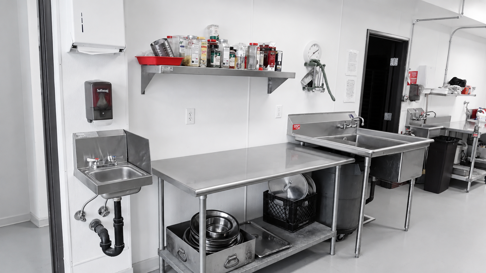Stainless steel prep table and sinks inside the Gourmet Garage commercial commissary kitchen