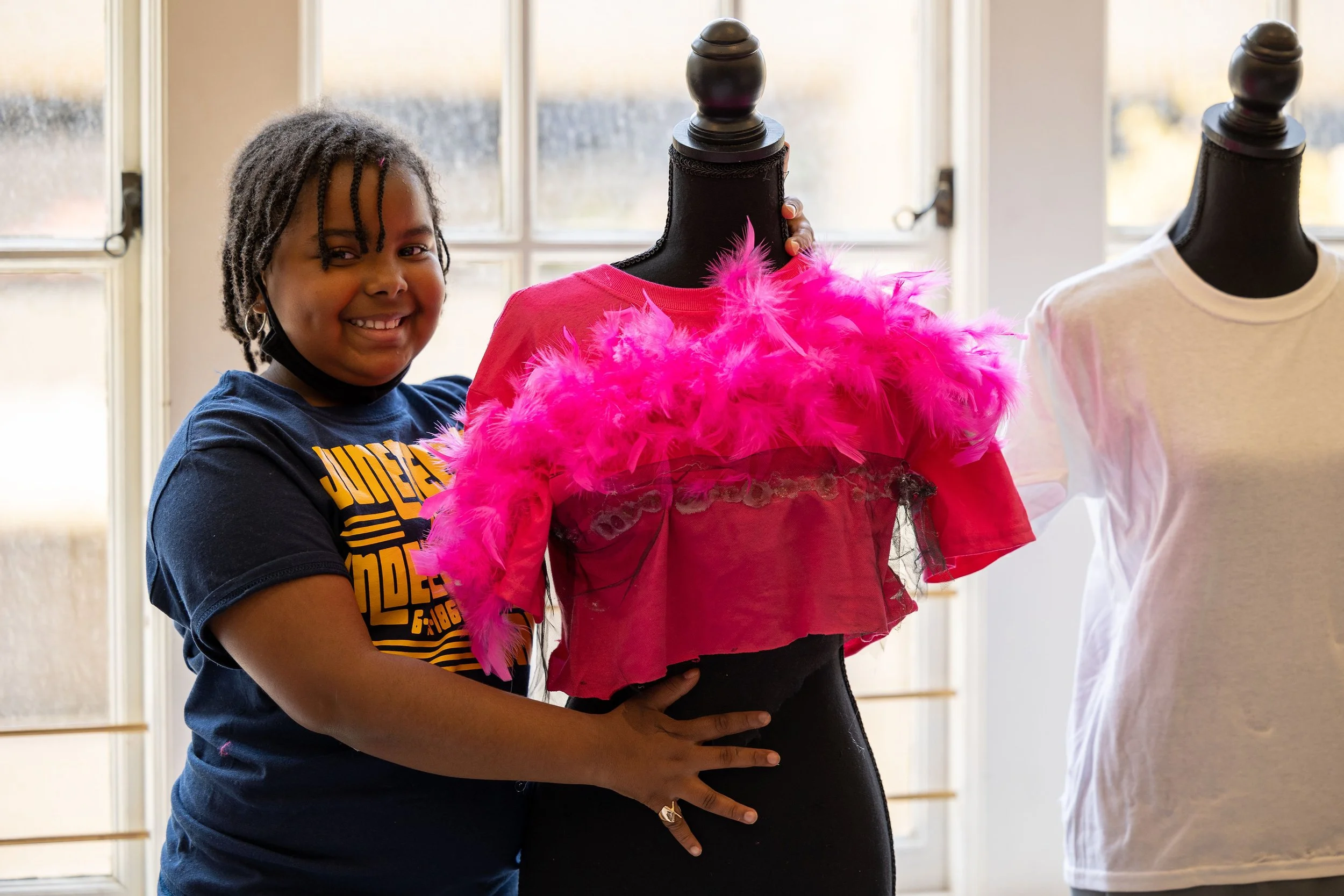 Girl making a gown during The Madame X Academy Oh, Sew Beautiful Black Fashion Experience 