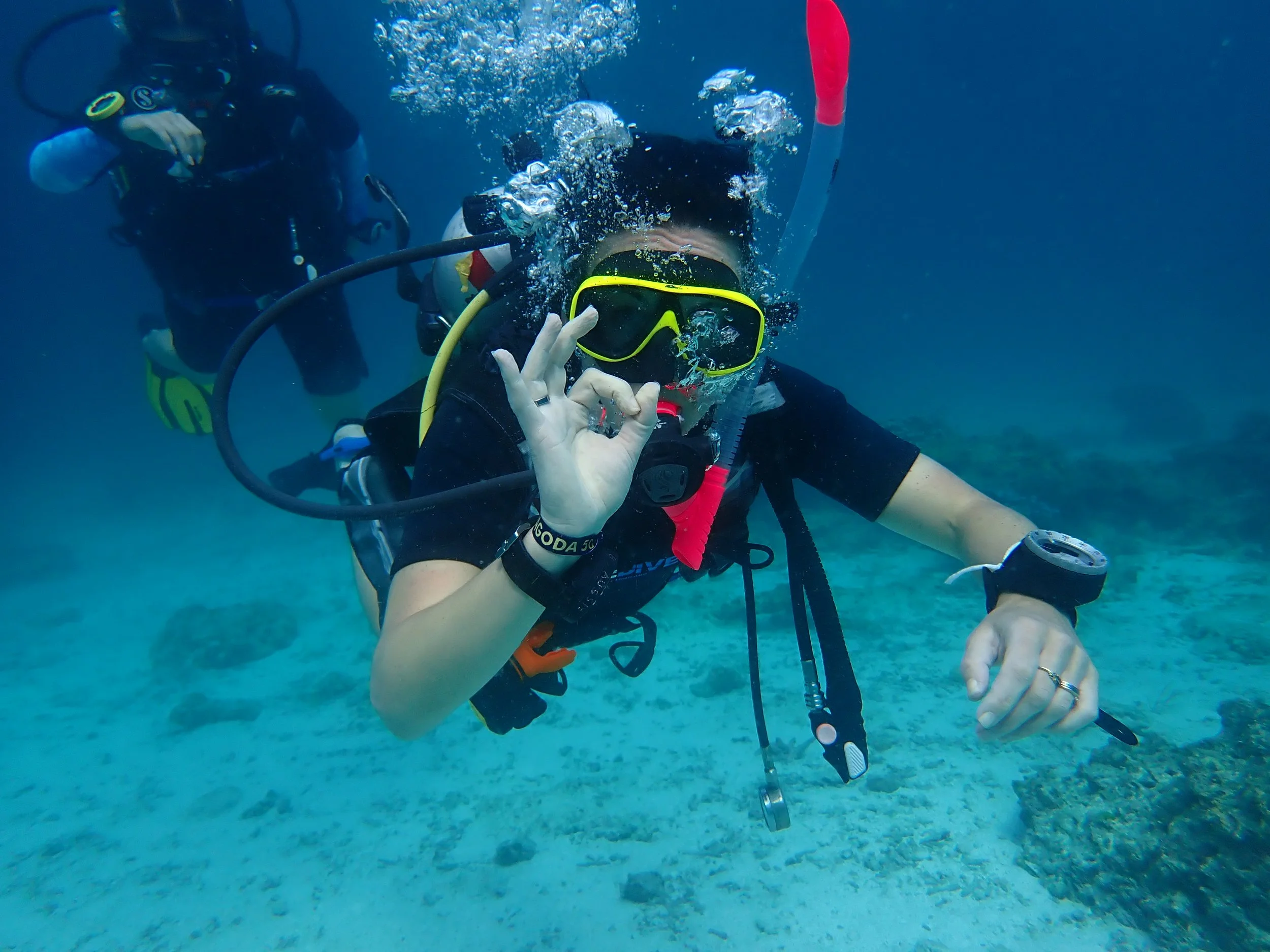 Plongeuse qui communique avec les mains OK en utilisant le pouce et l'index