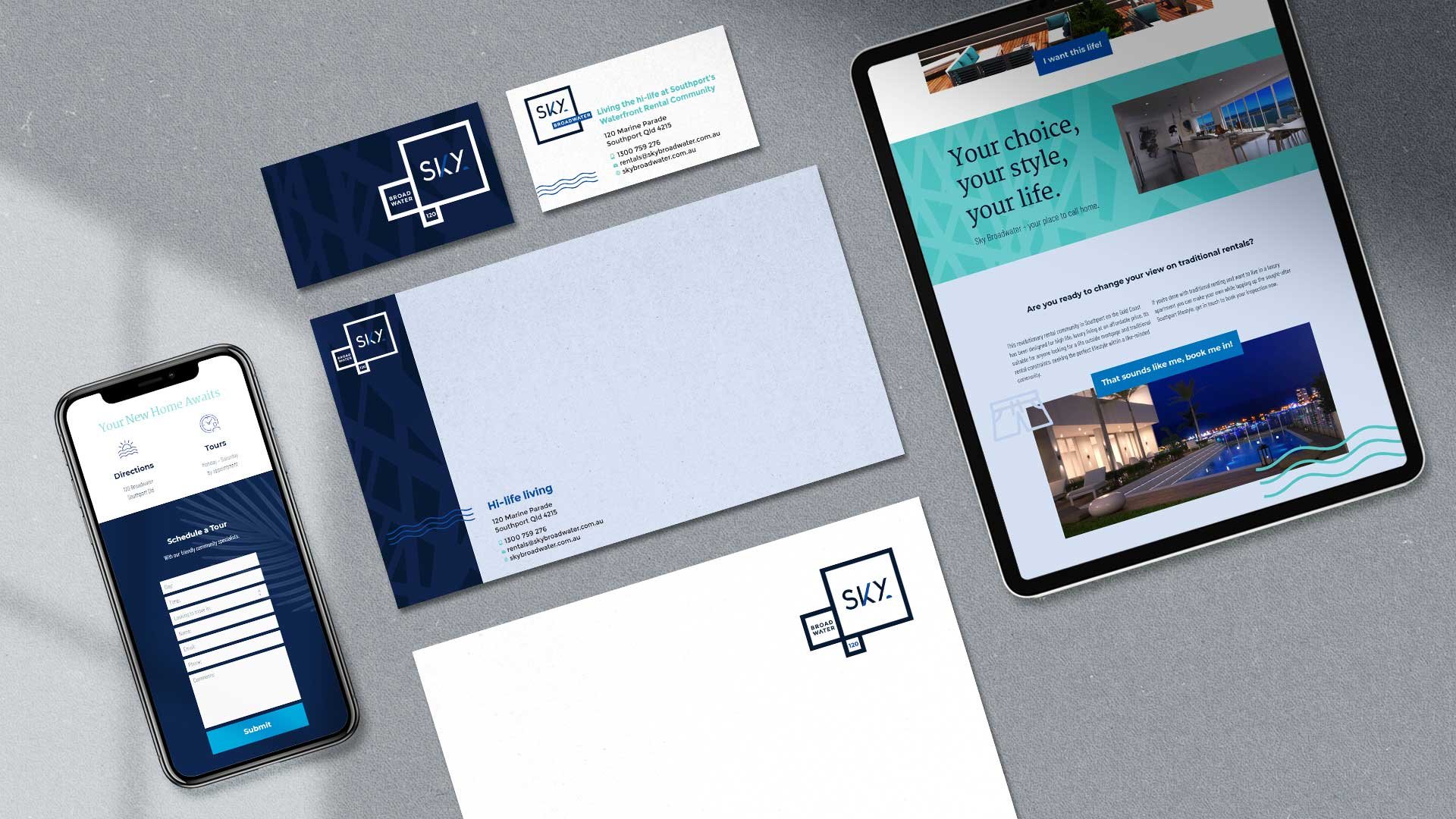 An assortment of real estate branding materials featuring the 'SKY' brand, including business cards, a smartphone, and a tablet displaying the company's website, all set on a textured grey surface.