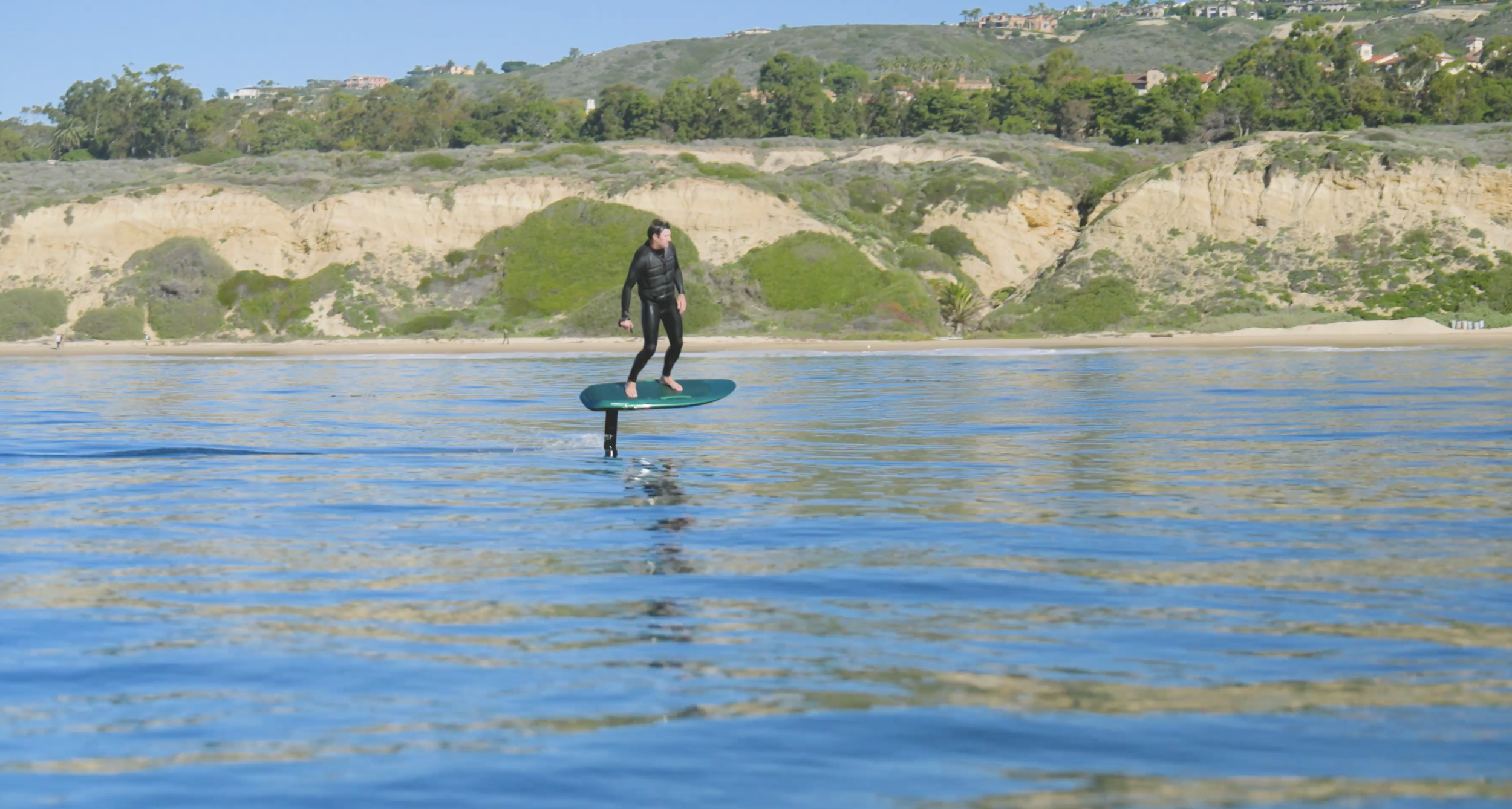 Crystal Cove fliteboarding session with one rider gliding silently above the water along the iconic Southern California shoreline.