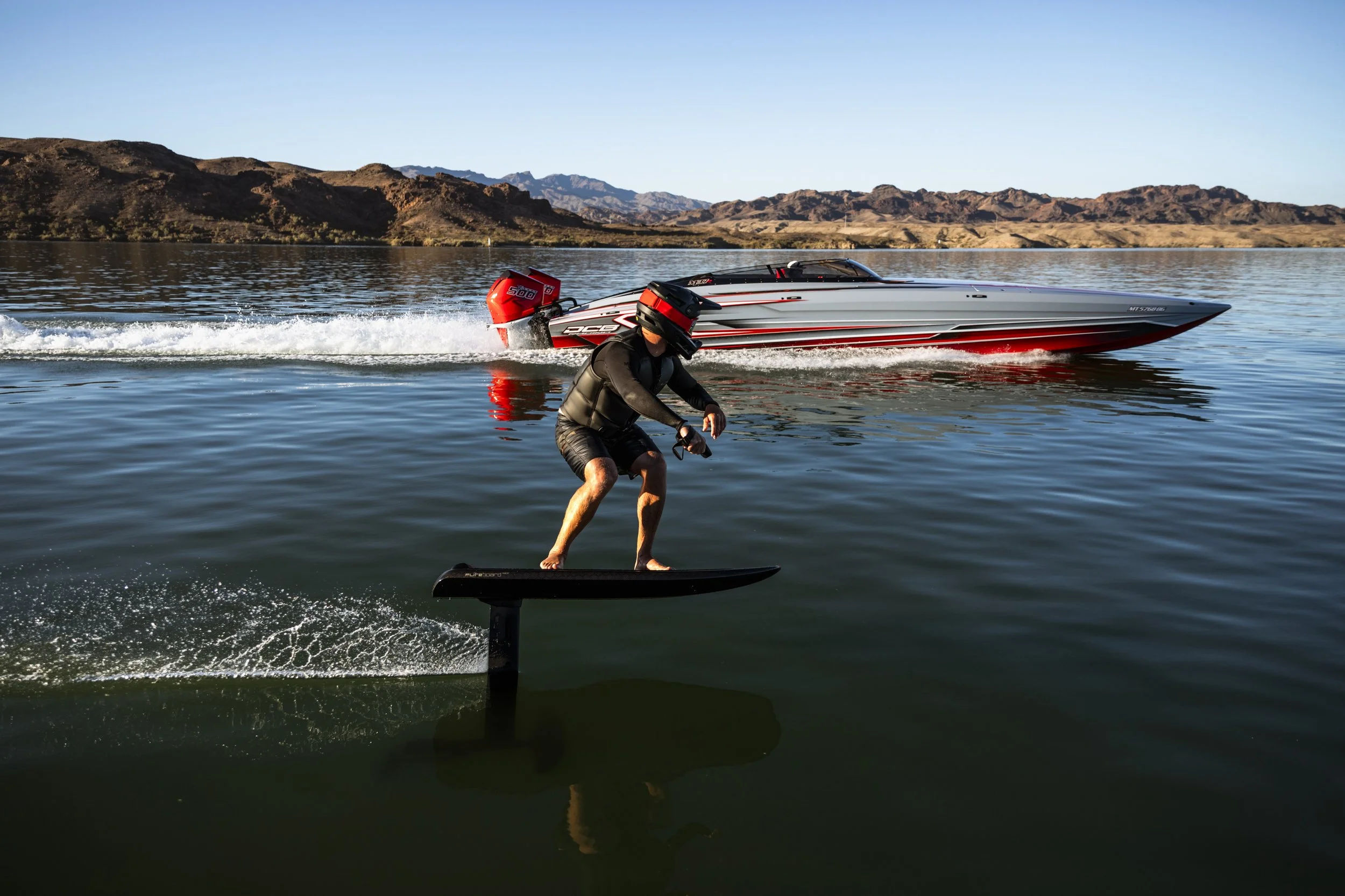 Rider on the Fliteboard Race eFoil riding alongside a Mercury Racing boat