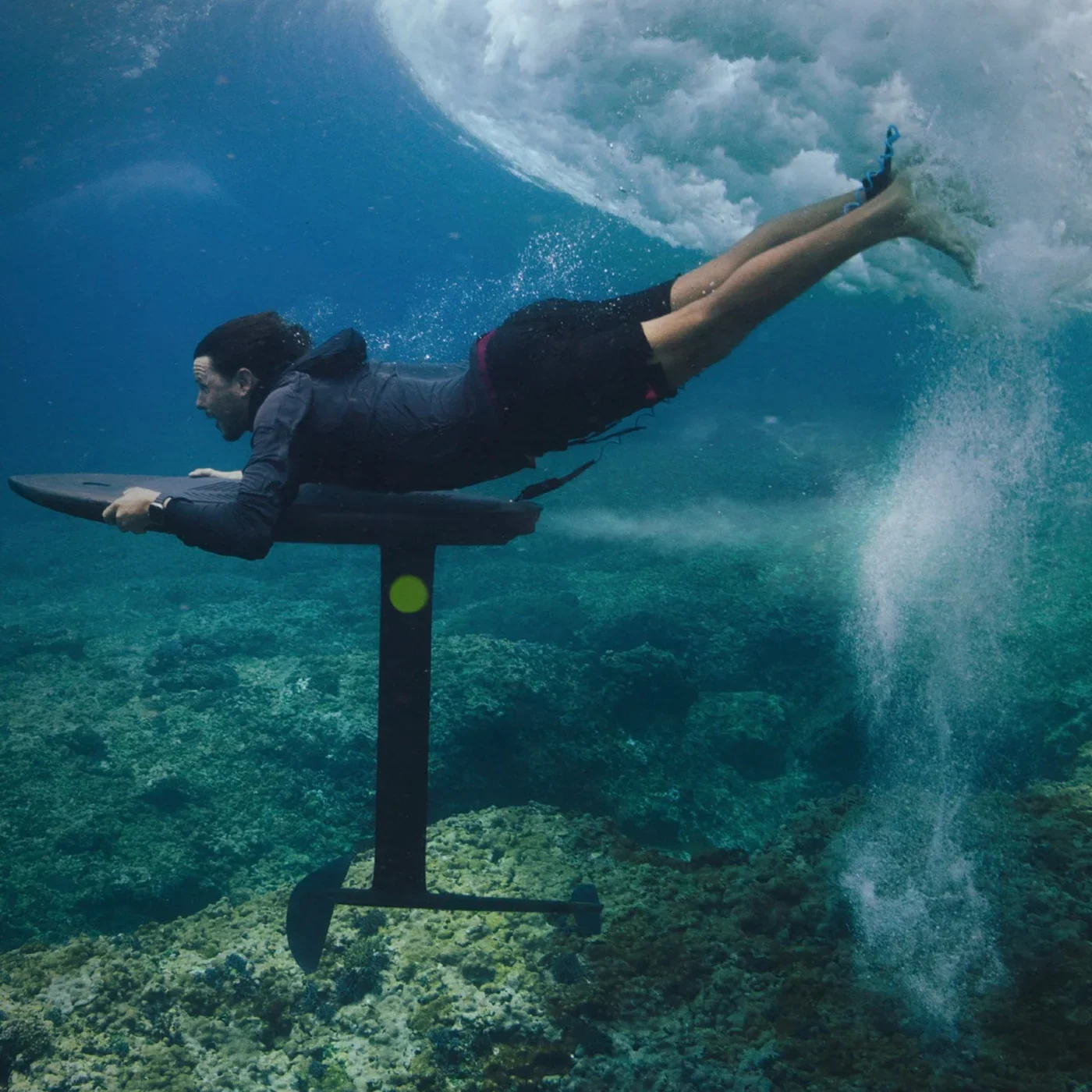 Rider duck diving underwater with a FLITELab AMP foil board