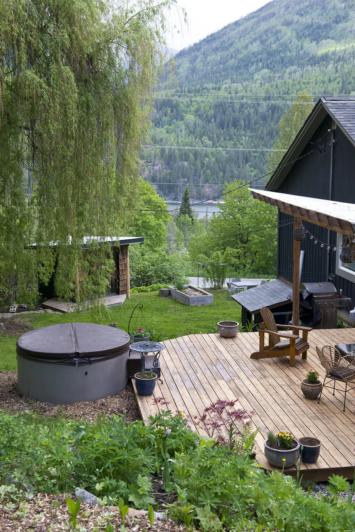 Private deck and hot tub surrounded by gardens in Nelson, BC