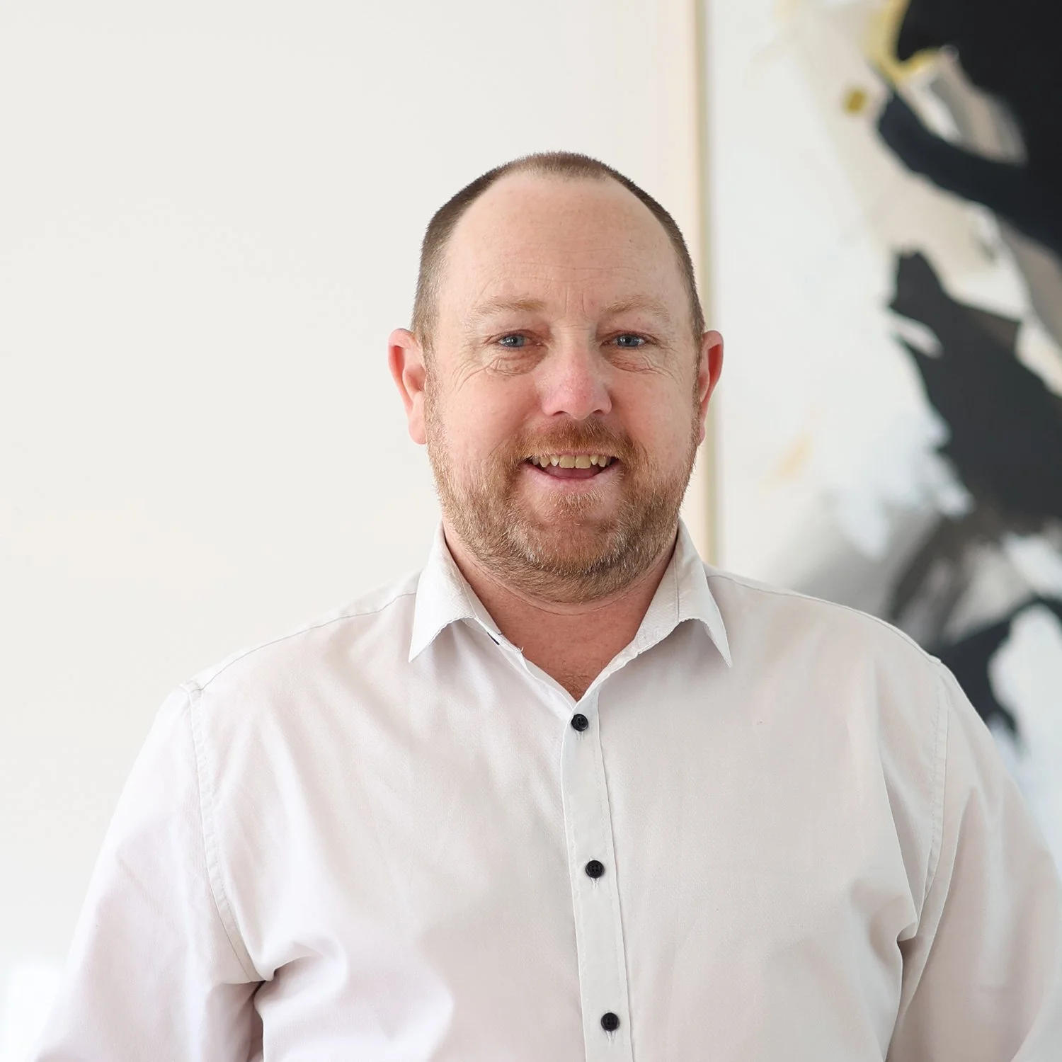 Brad Rayner, Credit Analyst at Sphere Home Loans with a beard and short hair wearing a white dress shirt.