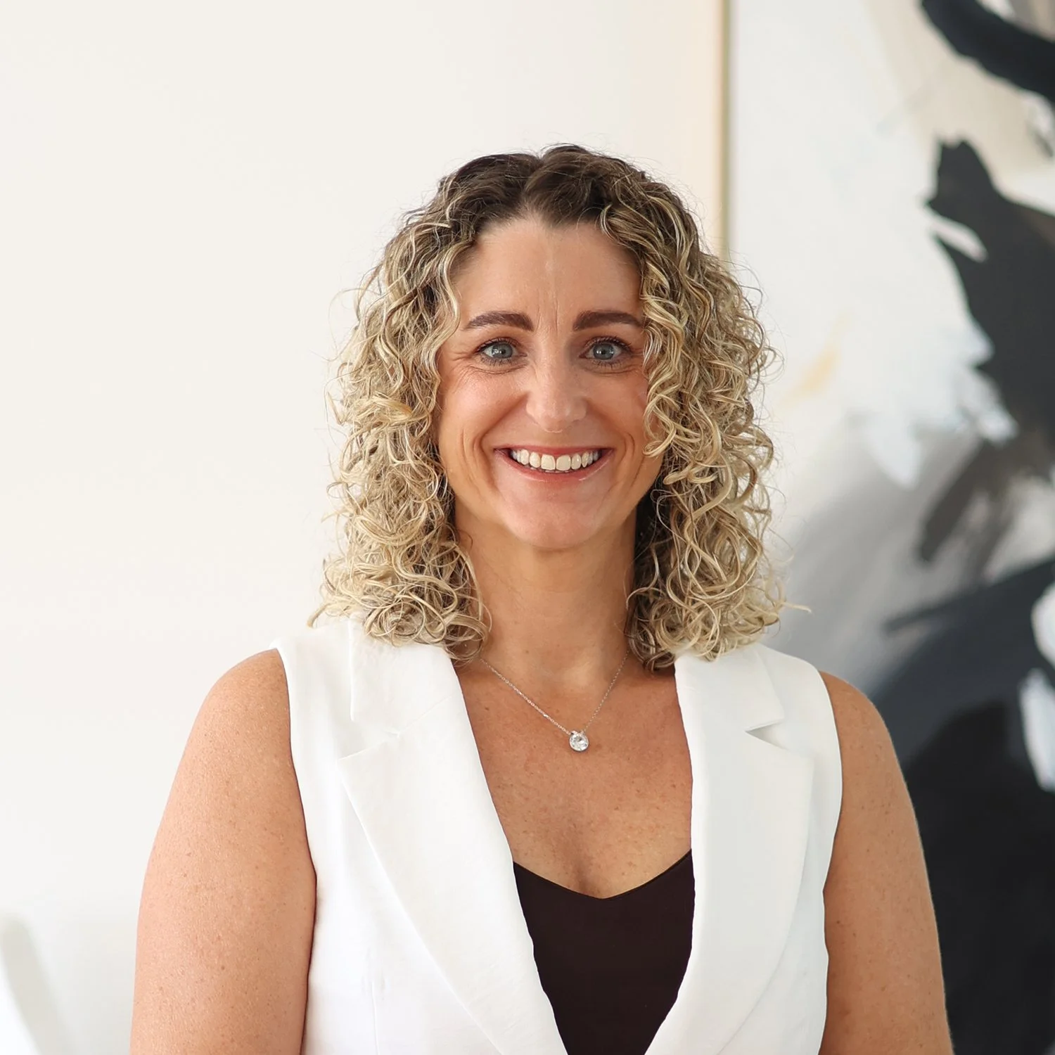 Karen Kirby
Senior Mortgage Broker at Sphere Home Loans with curly blonde hair, smiling, wearing a white sleeveless blazer over a black top