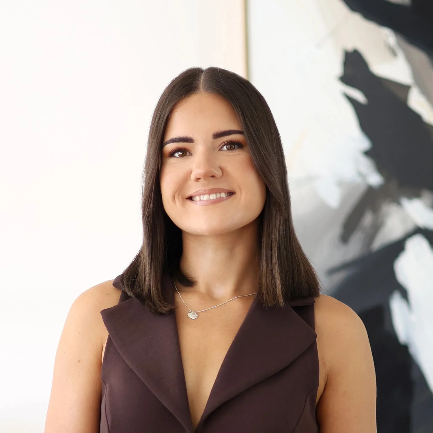 Sydney Wilks, Credit Analyst at Sphere Home Loans with shoulder-length dark brown hair, wearing a sleeveless brown top.