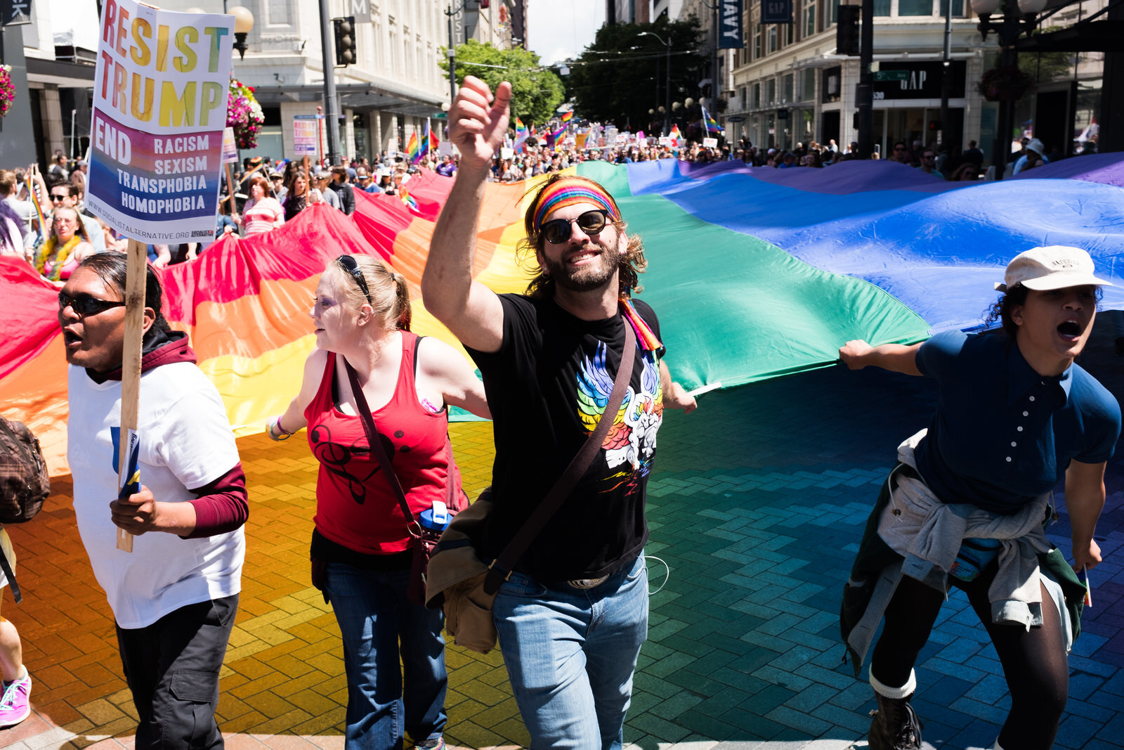 Activists carry a giant rainbow flag past Westlake Center in downtown Seattle during the Pride March on June 11th, 2017.