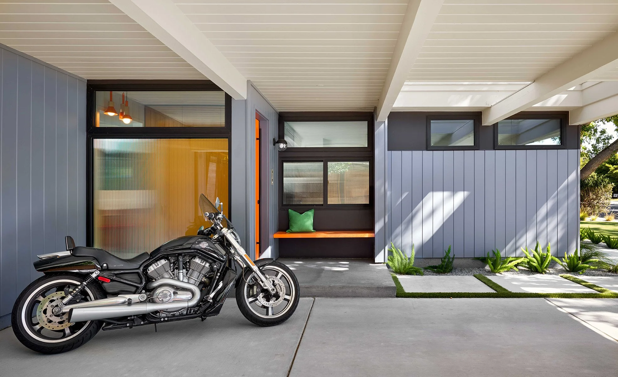 This Palo Alto Eichler got its lines back. We opened and simplified the carport structure, added a protected entry, and introduced a pop of orange at the door&mdash;classic Eichler energy. New vertical siding, darker window trim, and fresh clerestori