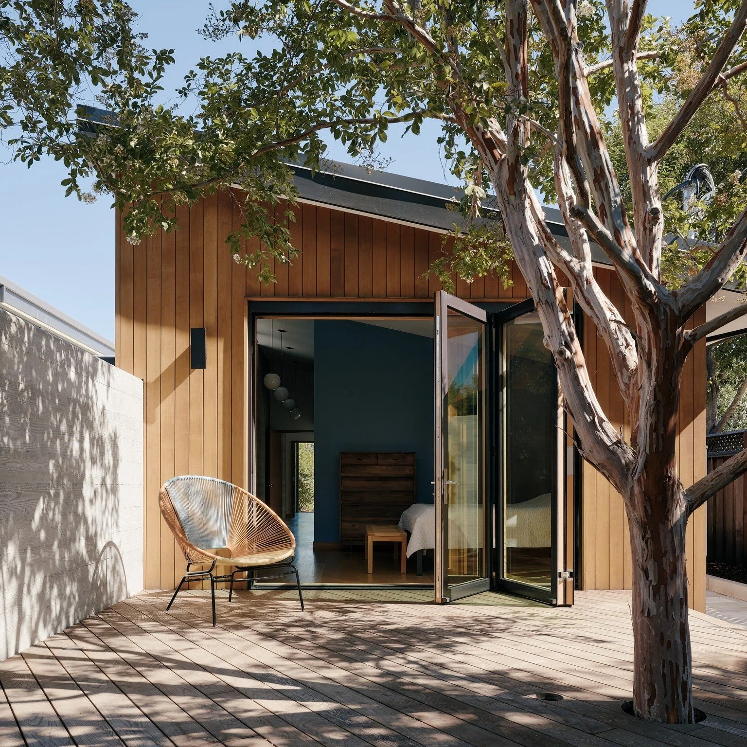 This Los Altos home is organized around a central great room and a sunken courtyard, both anchored by a board-formed concrete wall. Bedroom wings flank the spine, each with its own private outdoor space. Warm cedar, clerestories, and deep overhangs b