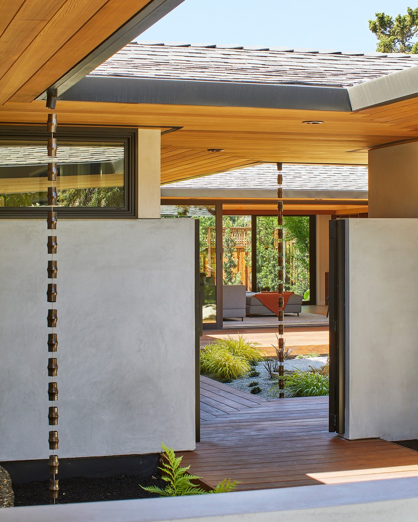 Mid-century calm complemented by Japanese influences. Rain chains are arranged like elements in a garden, guiding water off the roof with a gentle rhythm. A wraparound deck forms an engawa, an elevated walkway for walking, stopping, and looking out. 