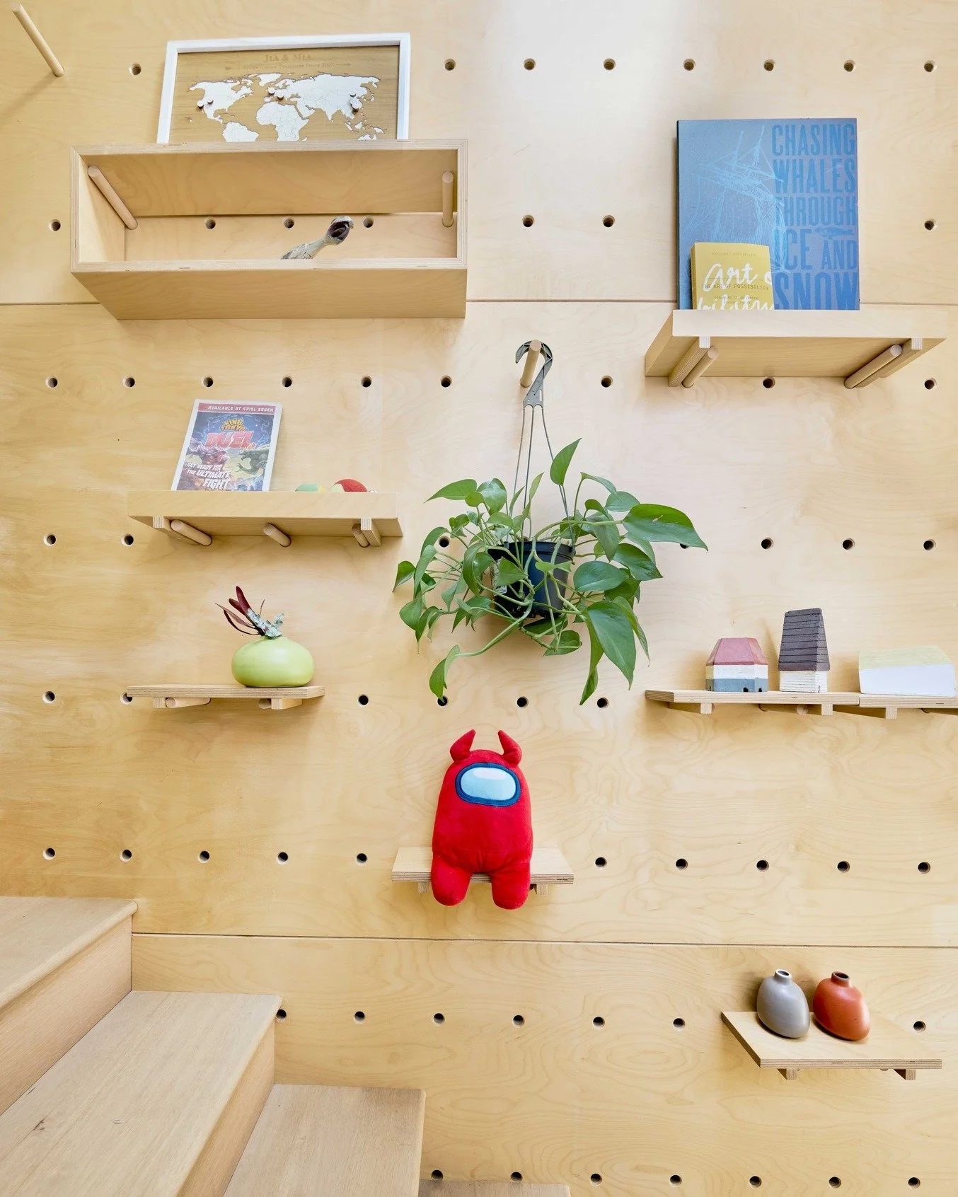 A pegboard for real life. 
Custom-designed and built for a busy family, this floor-to-ceiling birch pegboard lives alongside the stair, shelves, hooks, boxes, and hangers, all repositionable as the family grows and changes. Books, plants, tiny vases,