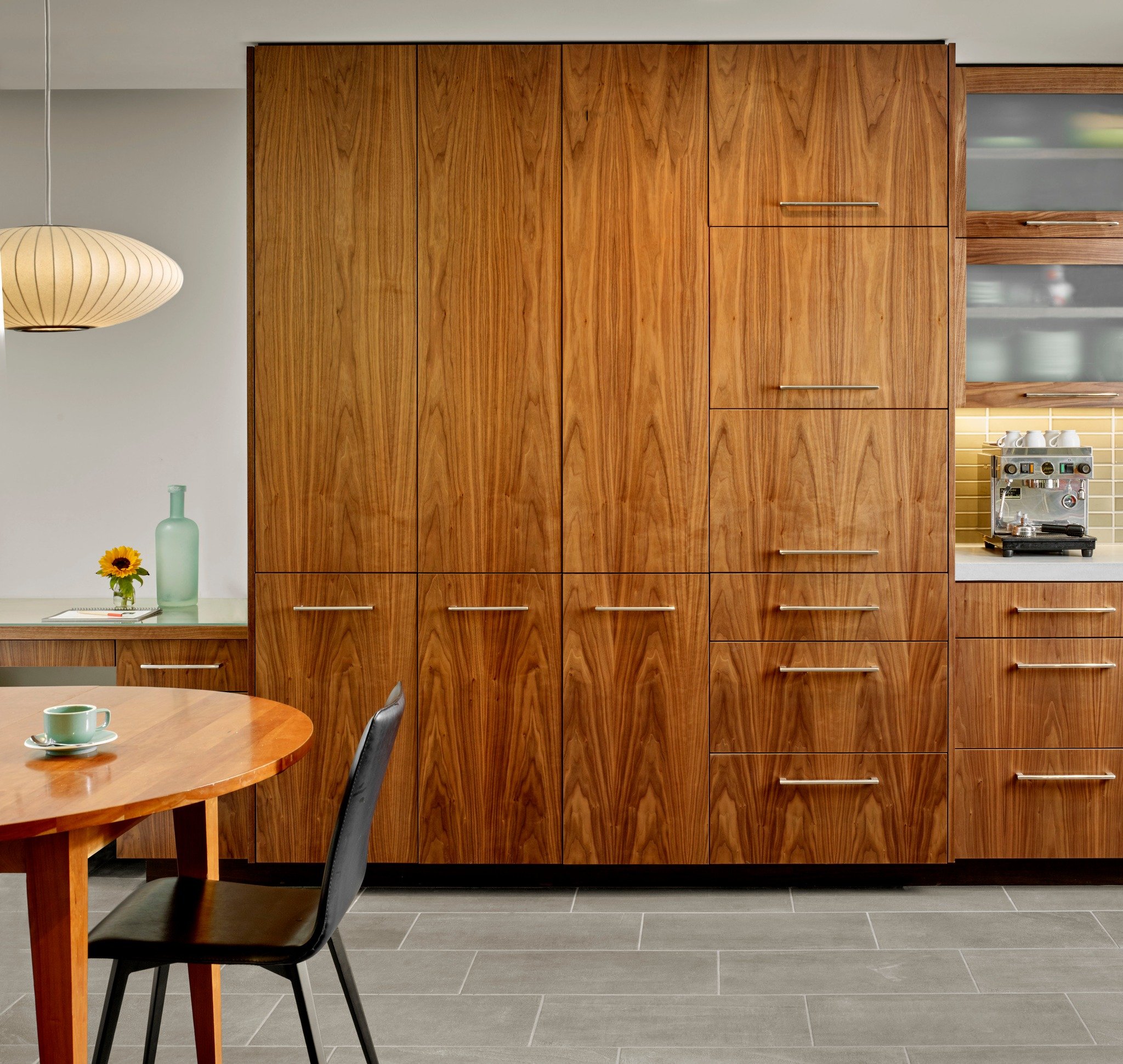 Closed: a beautiful wall of walnut. Open: everything in its place. 

Floor-to-ceiling book-matched walnut cabinetry in this kitchen does the heavy lifting:  a pull-out pantry, an appliance bay with a lift-up door, deep pot drawers, all tucked behind 