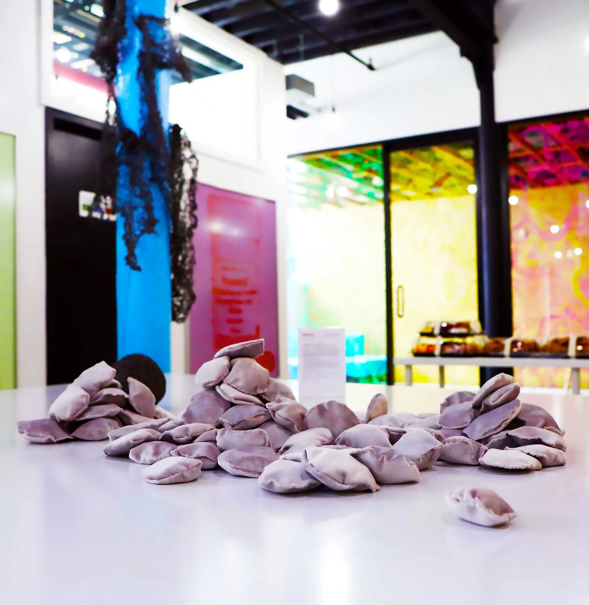  Velvet Stones (Process) ; Creek-collected stones, vintage lavender velvet, sewing materials; 100 count; As installed at NOGO Arts; Brooklyn, NYC; 2019.