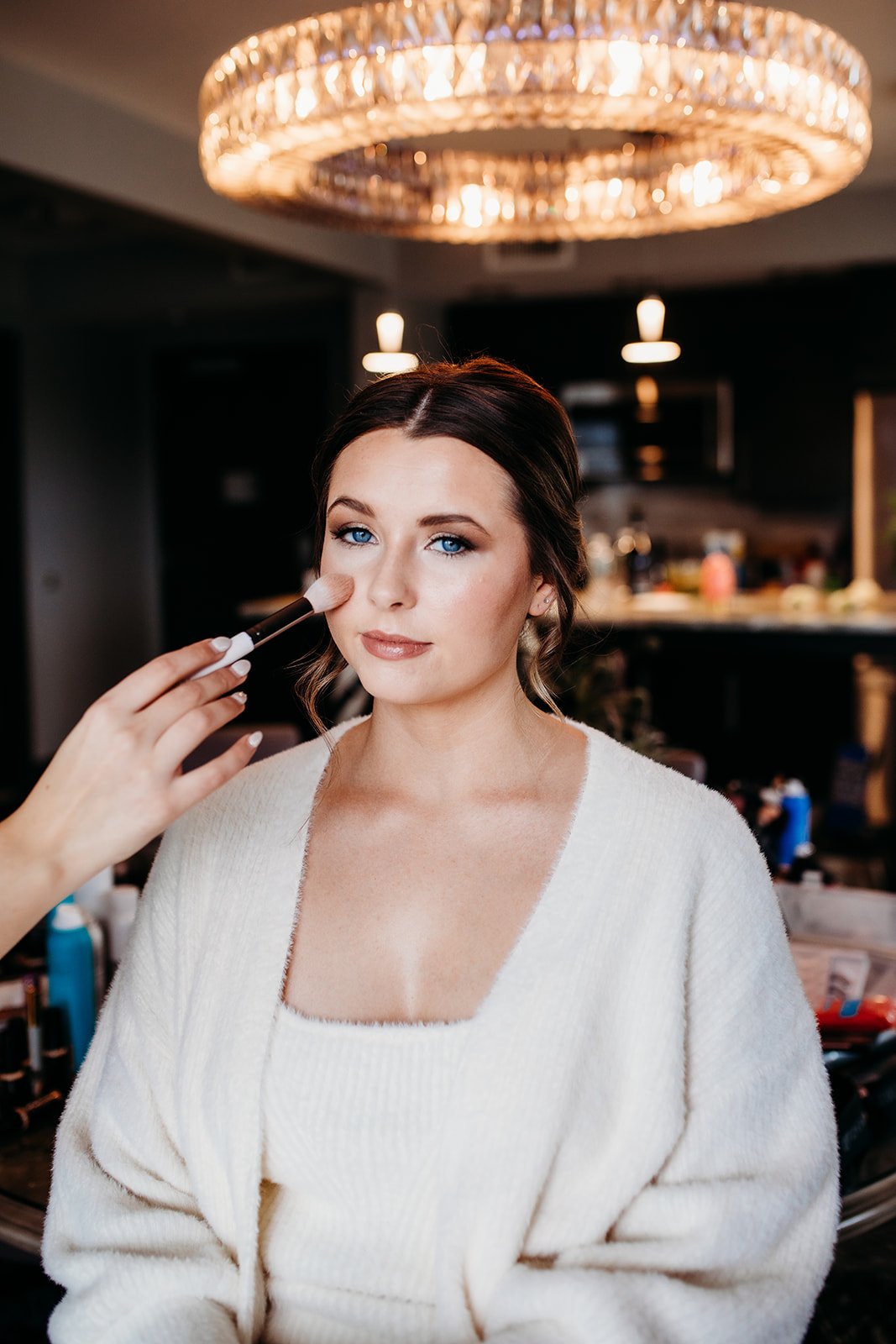 makeup artist brushes makeup on bride's face