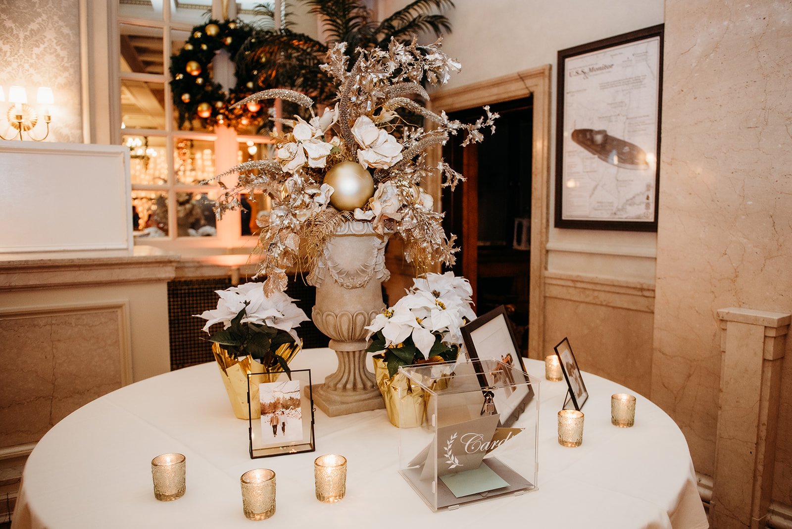 welcome table with gold candles and white flowers for winter reception