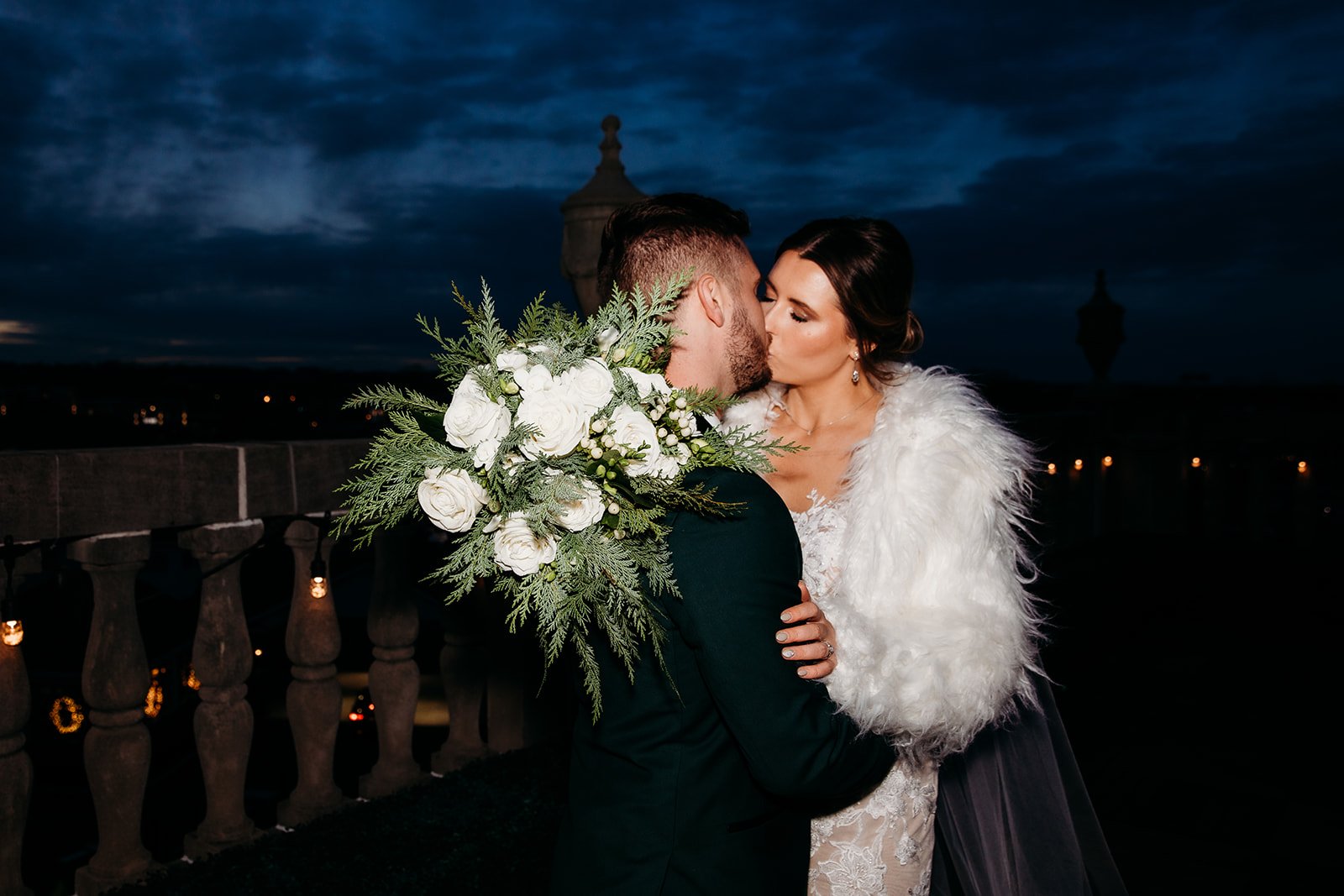 bride and groom kiss during winter wedding reception 