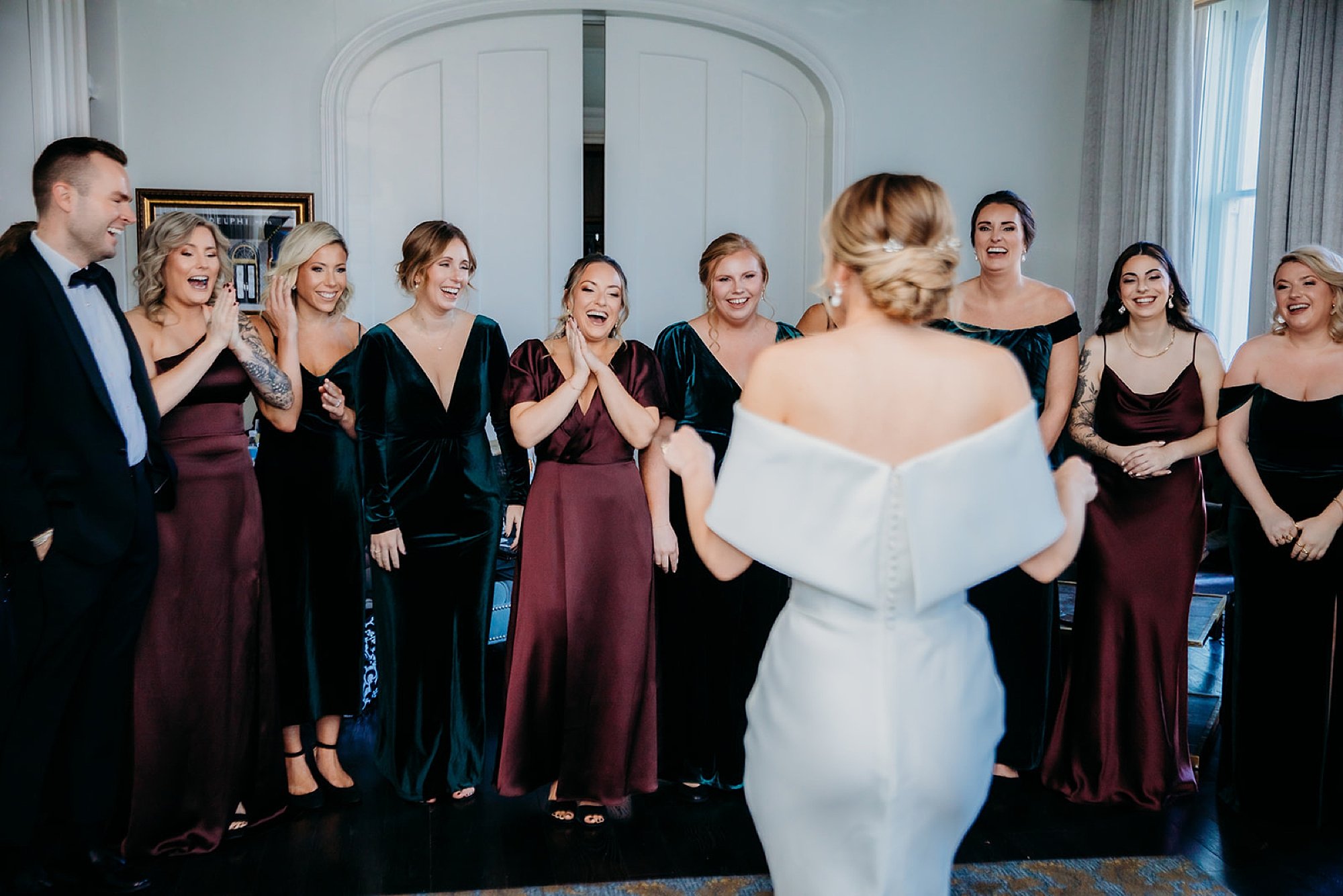 bride shows off wedding look to bridal party at The Adelphi Hotel