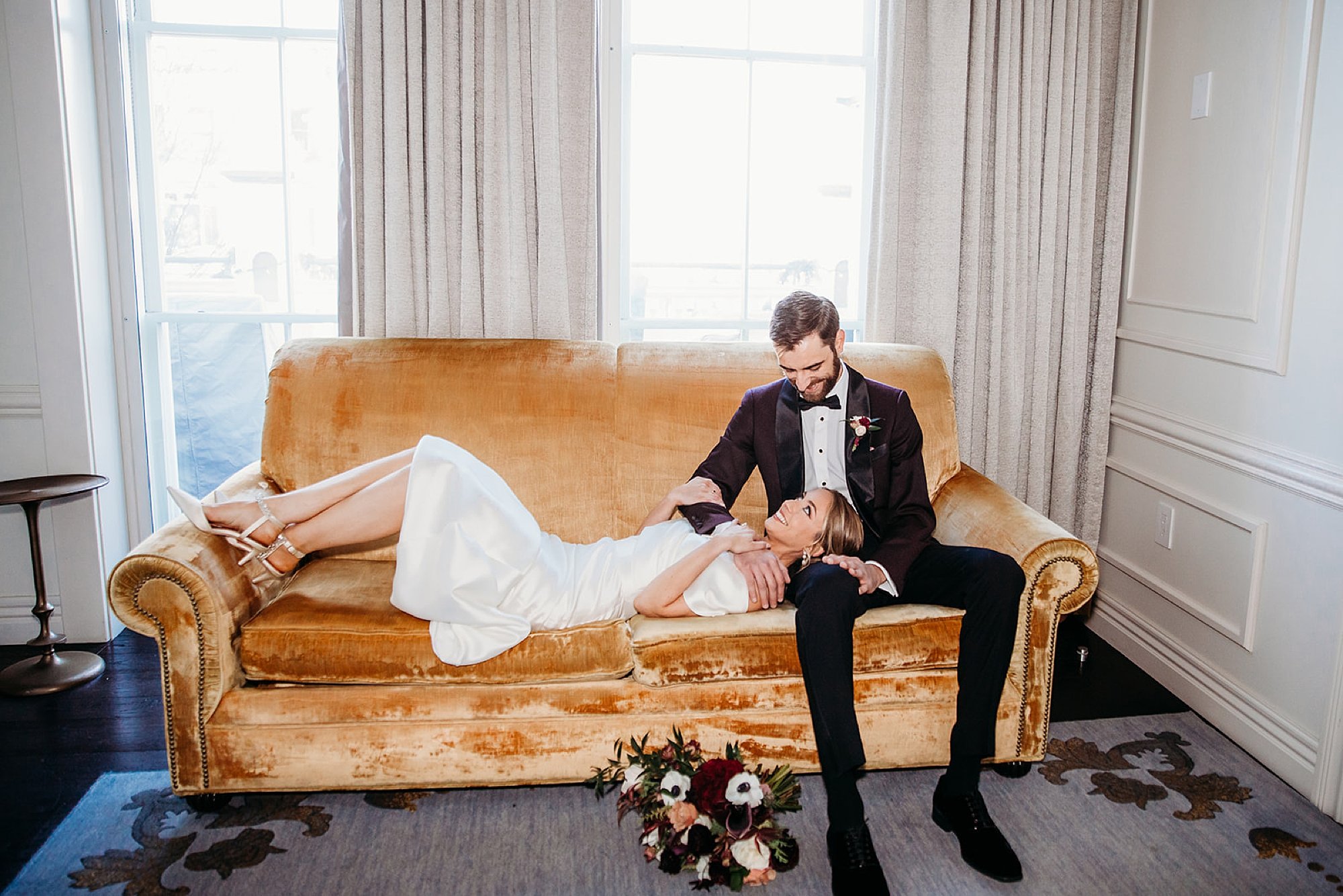 bride and groom sit on couch in lobby at The Adelphi Hotel