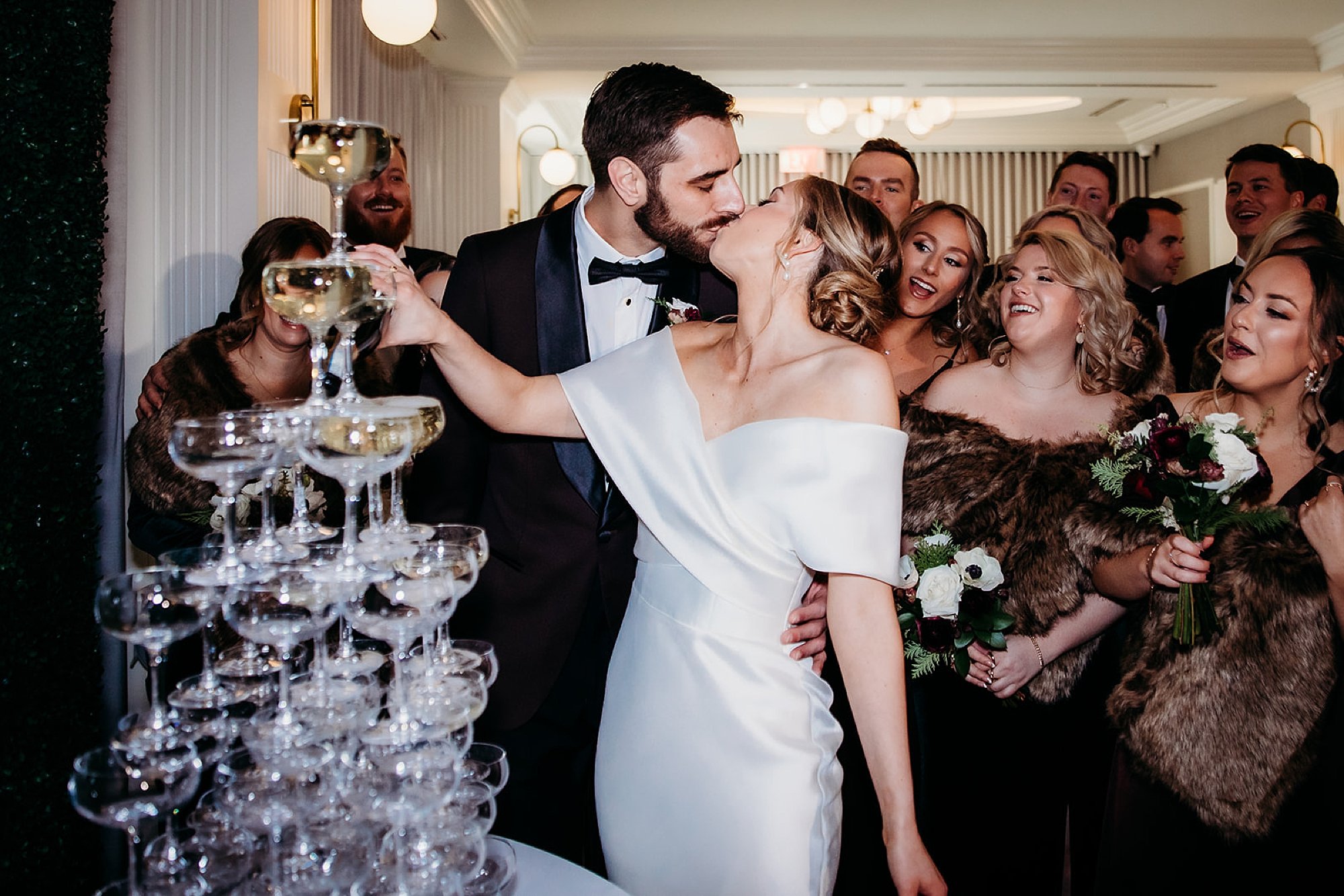 newlyweds kiss pouring Champagne down tower of glasses 