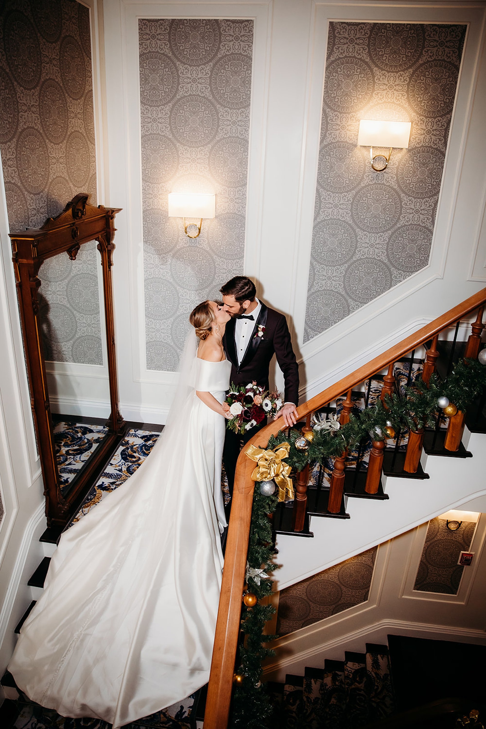 bride and groom kiss on staircase inside The Adelphi Hotel