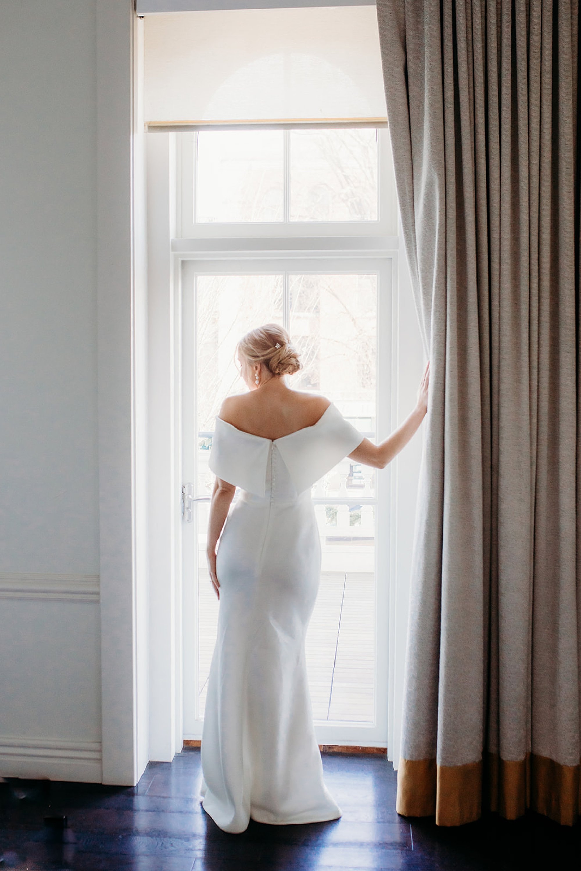 bride poses in window at The Adelphi Hotel
