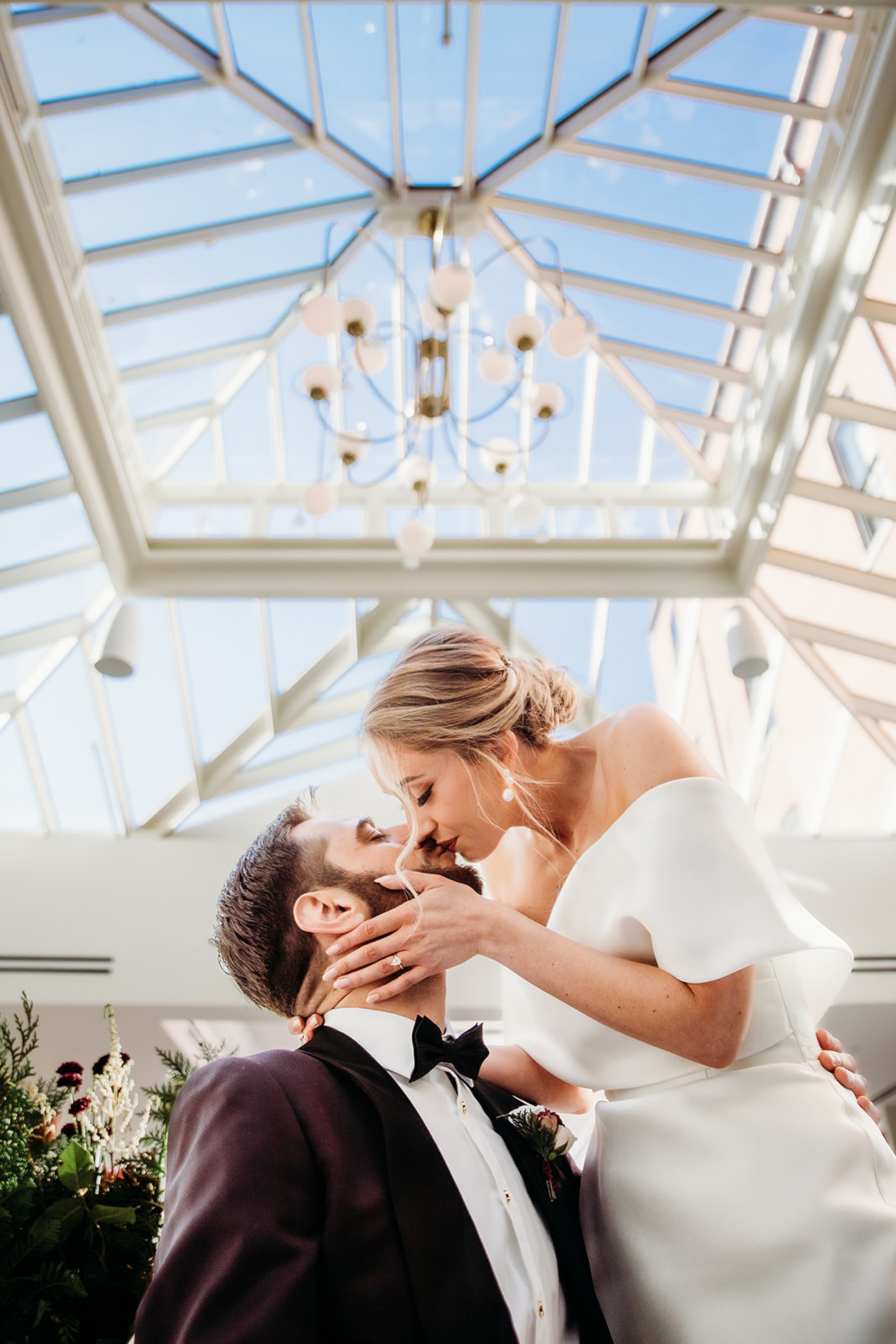 bride and groom kiss in atrium at The Adelphi Hotel